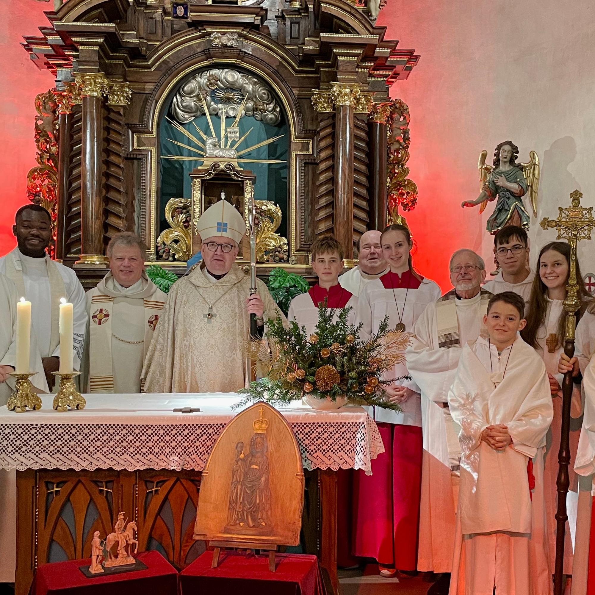 .l.: Diakon Volkmar Raabe, Kaplan Cornelius Agbo, Leitender Pfarrer Harald Poggel, Bischof Peter Kohlgraf, Pfarrer Jozef Koscielny, Pfarrer i.R. Januarius Mäurer und Messdienern aus Hesselbach, Beerfelden, Vielbrunn und Lützelbach – Vordergrund Bildnis der Schwarzen Madonna des Odenwaldes und der kleinen Statue des heiligen Martin