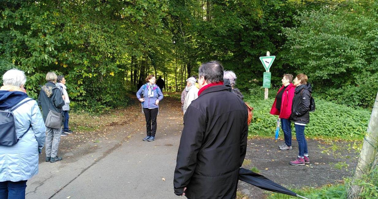Die Pilgergruppe steht vor dem Eingang zum Wald richtung Gießen. Pfarrerin Schneider gibt Anregungen für den gemeinsamen Pilgerweg.