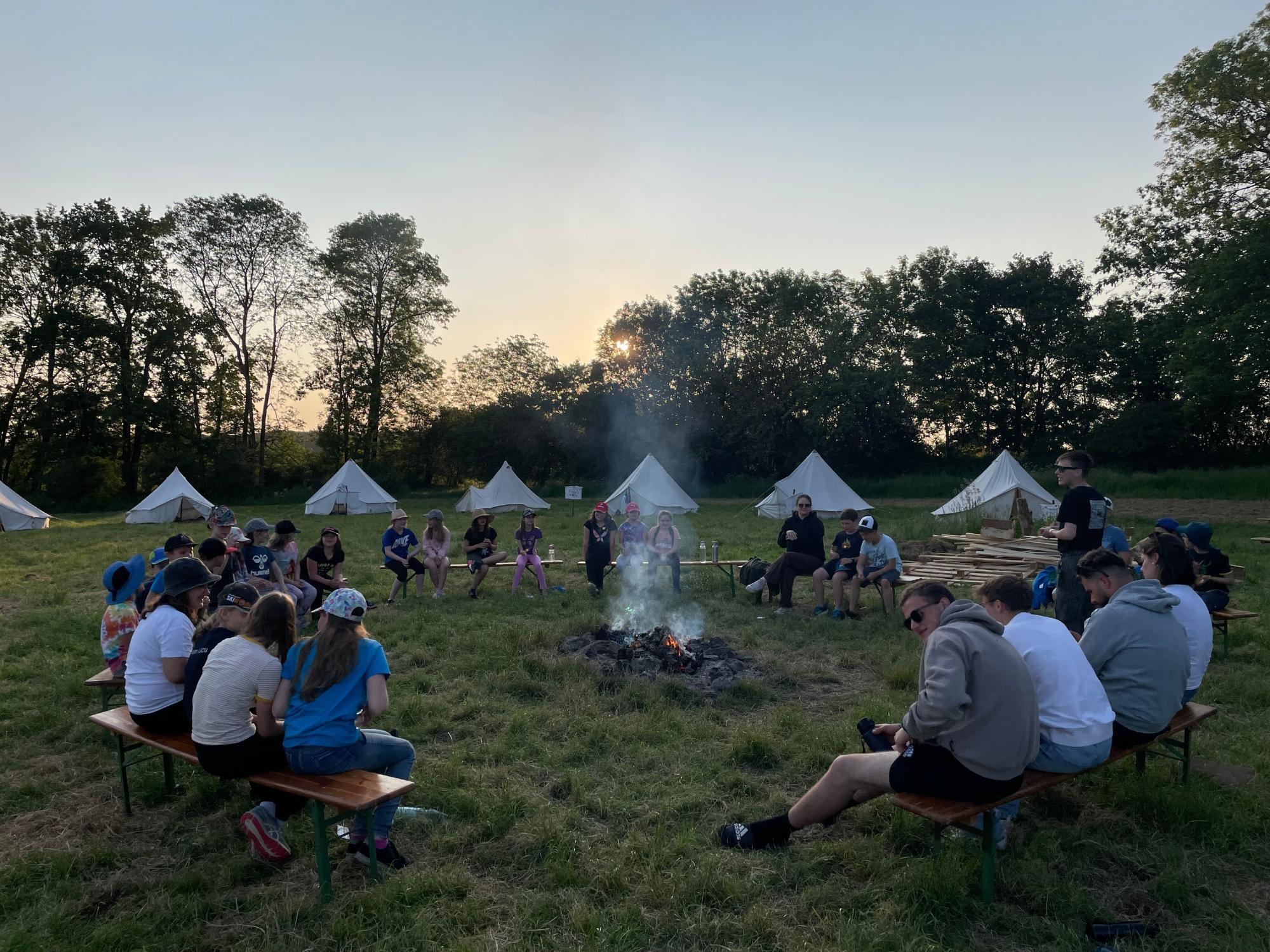 Zeltlageratmosphäre: gemeinsames Sitzen ums Lagerfeuer