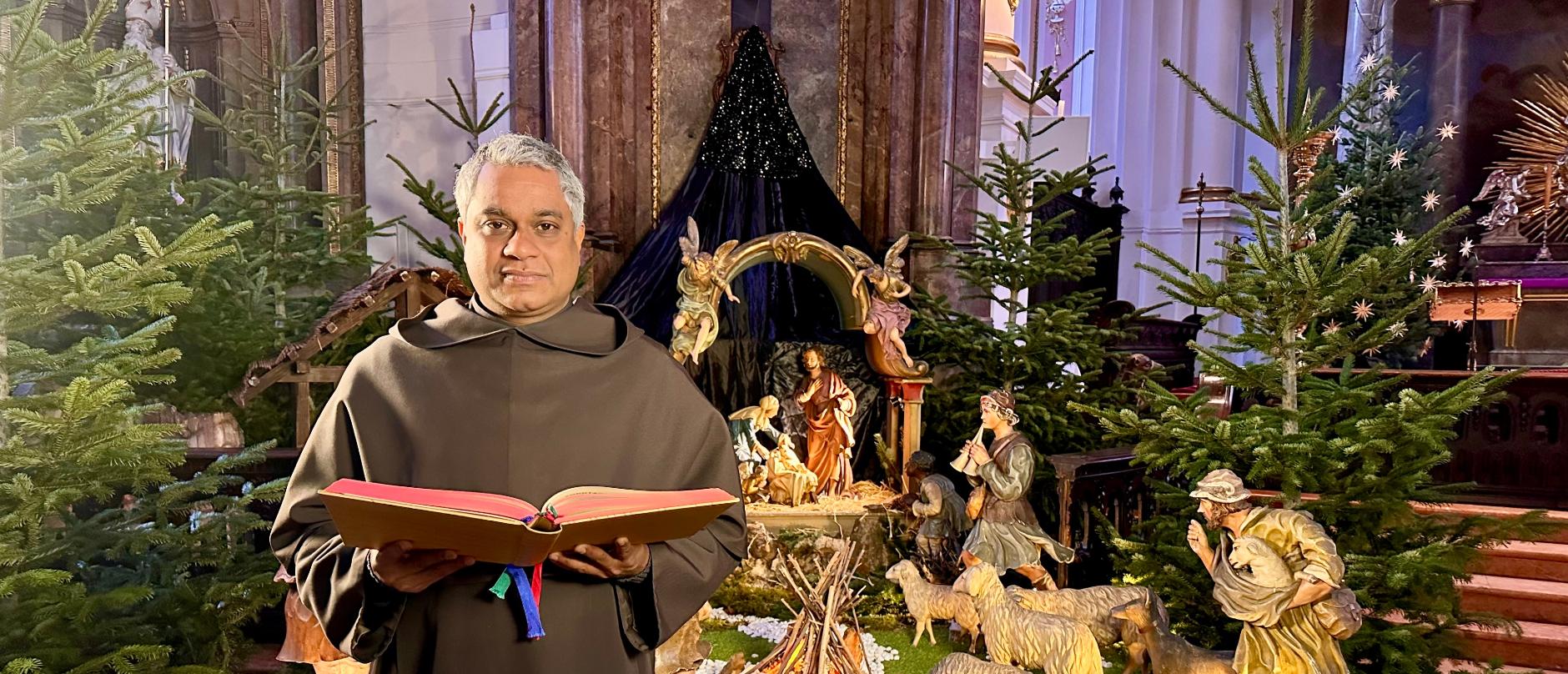 Pater Joshy G. Pottackal liest das Weihnachtsevangelium an der Krippe von St. Ignaz
