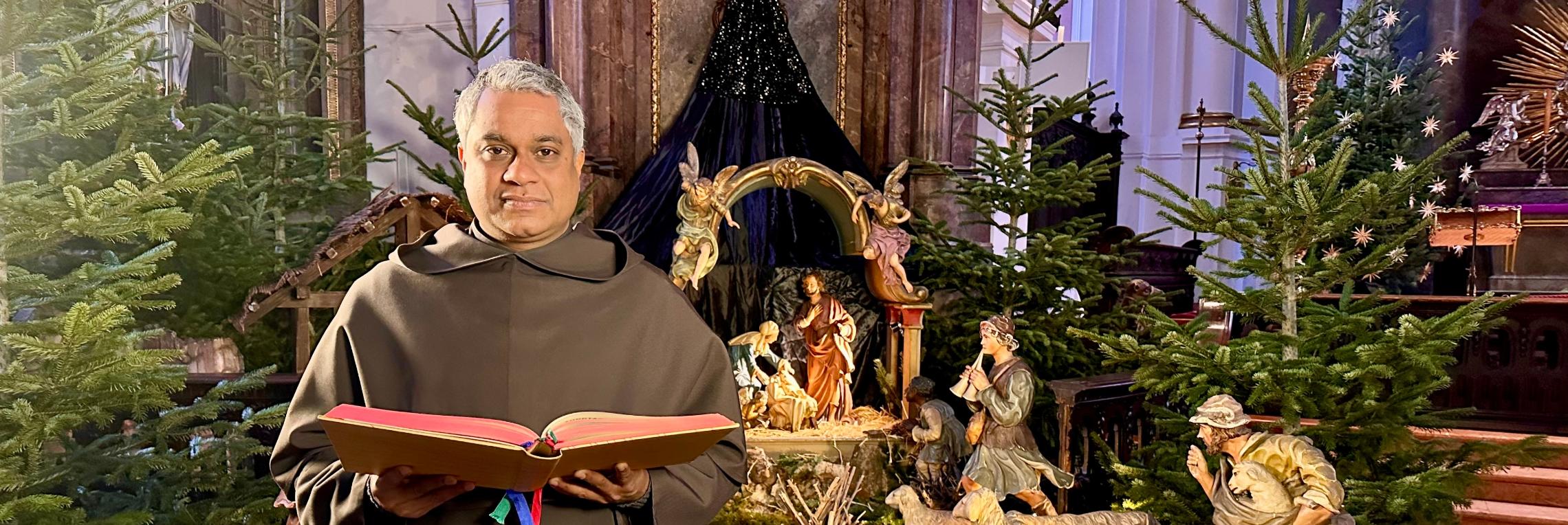 Pater Joshy G. Pottackal liest das Weihnachtsevangelium an der Krippe von St. Ignaz