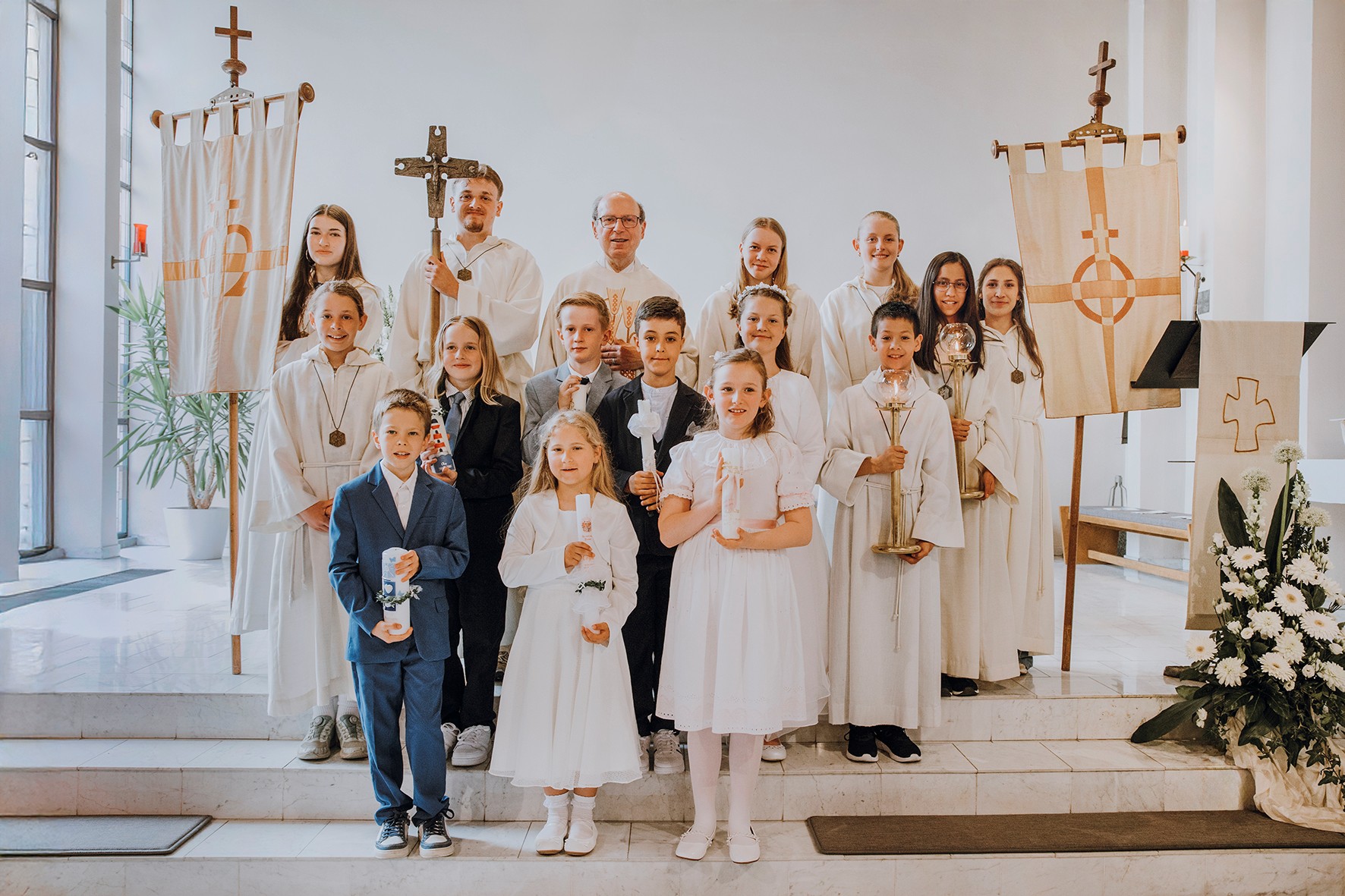 Die Rodheimer Erstkommunionkinder 2026 mit Pfarrer Norbert Braun im Kreis der Ministranten.