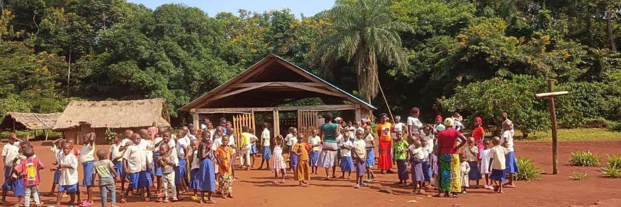 Die Kinder und Eltern vor Häusern des Dorfes