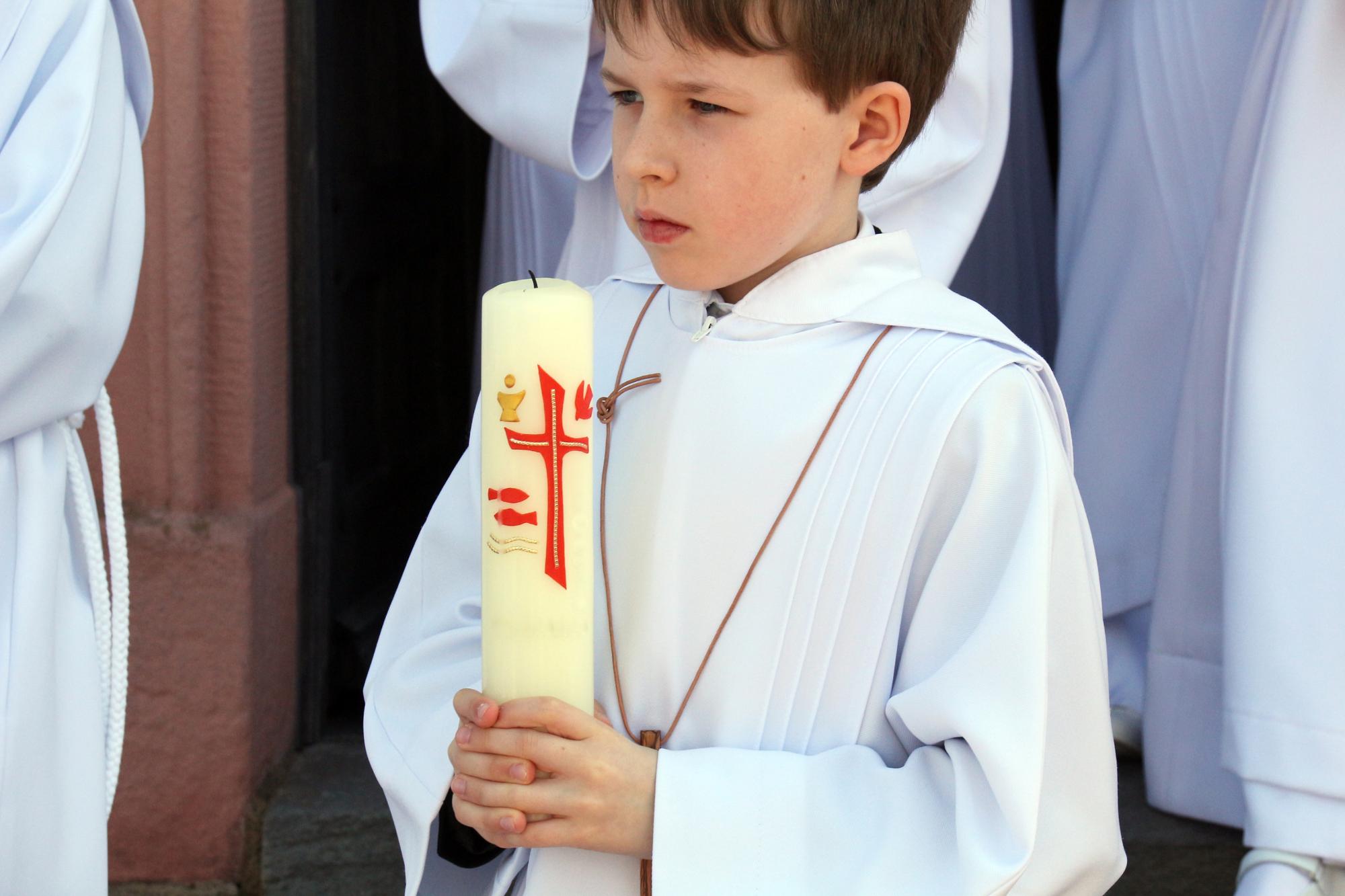 Erstkommunionkind mit Kerze