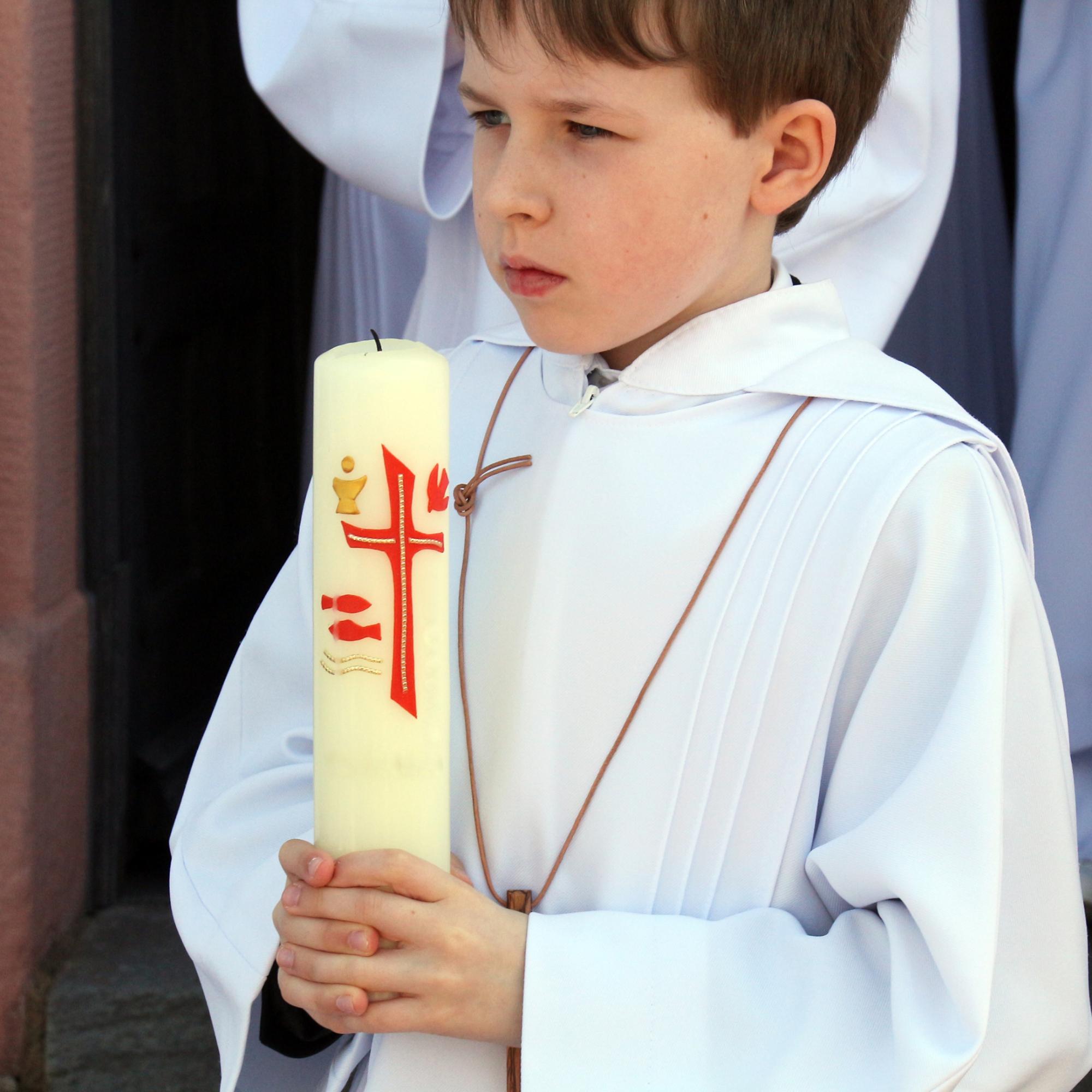 Erstkommunionkind mit Kerze