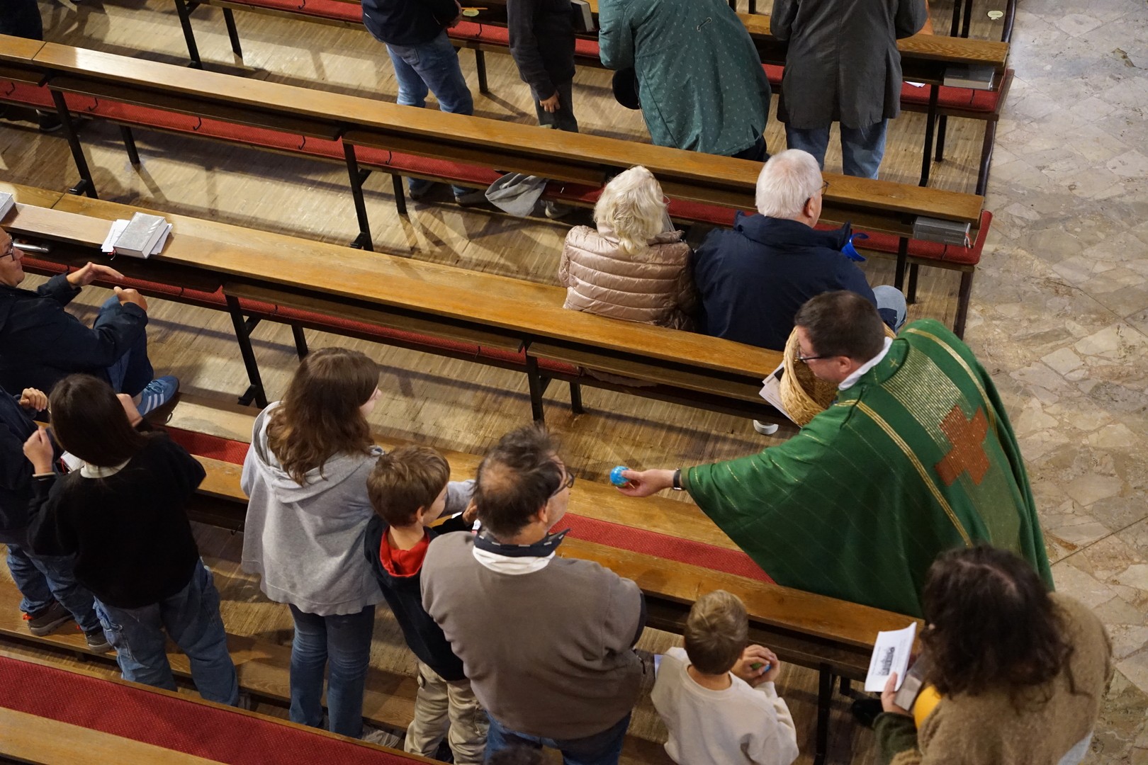 Nach dem Gottesdienst verschenkt Pfarrer Wornath kleine Weltkugelbälle. (c) P. Knobloch
