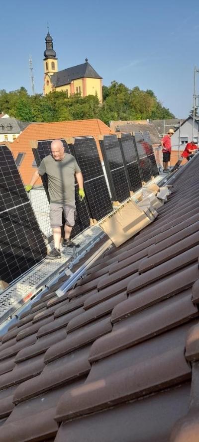 Die PV-Module der Photovoltaikanlage werde auf dem Dach des Pfarrzentrums montiert
