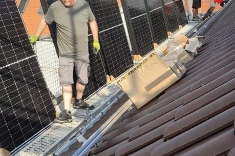 Die PV-Module der Photovoltaikanlage werde auf dem Dach des Pfarrzentrums montiert