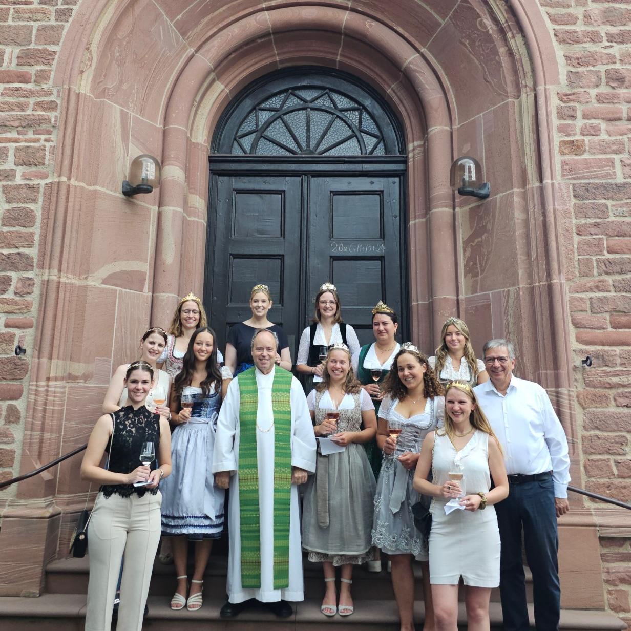 Weinmajestäten mit Pfarrer und OB Mende vor St. Kilian