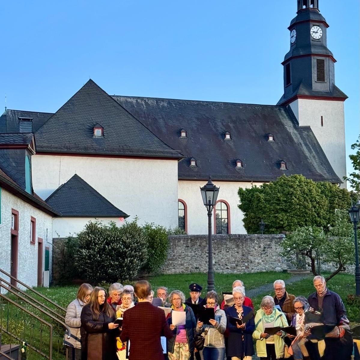 Blick vom Pfarrgarten auf St.-Remigius-Kirche mit Kirchenchor im Vordergrund