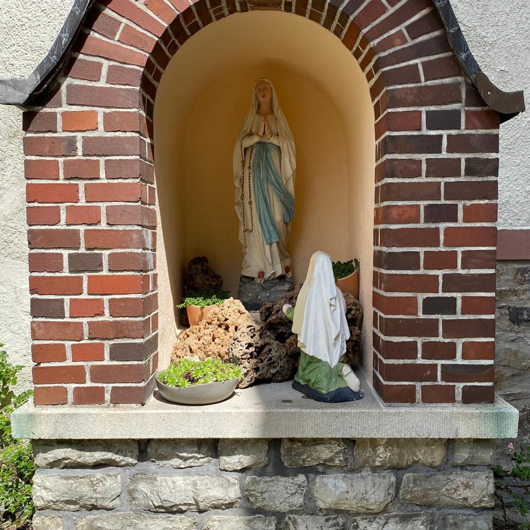 Lourdes-Grotte mit Madonnenfigur und Figur der heiligen Bernadette Soubirous
