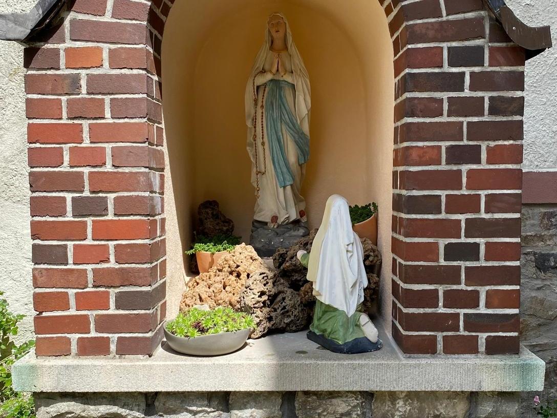 Lourdes-Grotte mit Madonnenfigur und Figur der heiligen Bernadette Soubirous