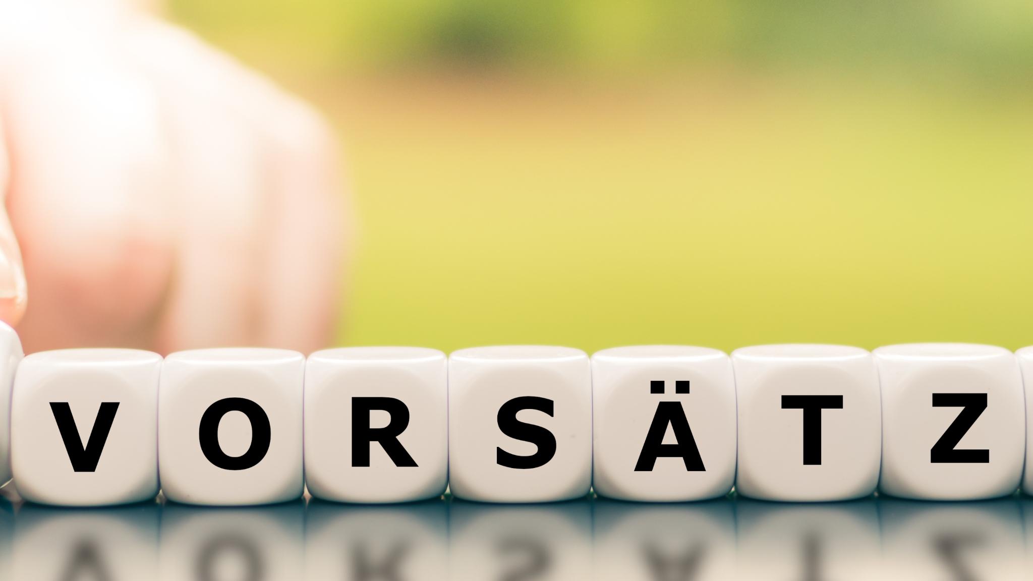 Hand dreht einen Würfel und ändert den Ausdruck 'keine Vorsätze' in 'gute Vorsätze'.