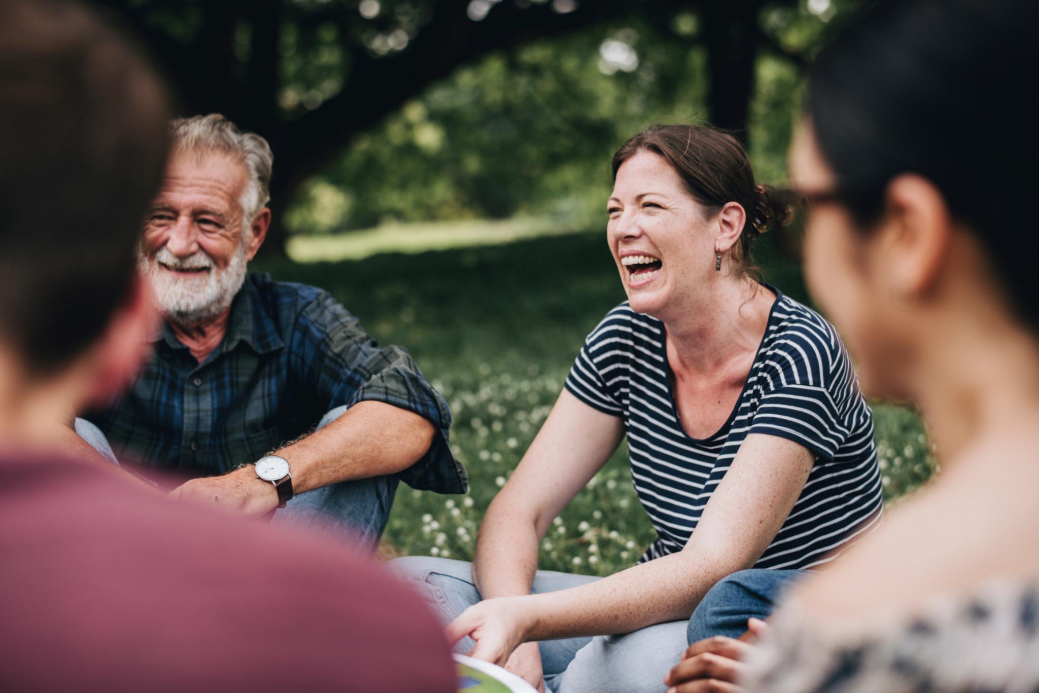 Heitere Frau im Park mit Freundinnen und Freunden