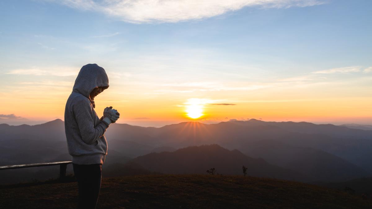 Betende Frau im Sonnenaufgang