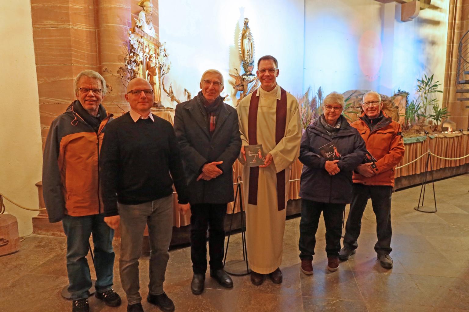 Autor Franz-Rudolf Weinert mit Stadtpfarrer Thomas Winter, umgeben von Mitwirkenden an Broschüre und Krippenbau (Personen v.l.: Fabian Herschel, Christian Albert, Weinert, Winter, Veronika Mauer-Bender und Werner Mauer). (c) Dr. Barbara Nichtweiß