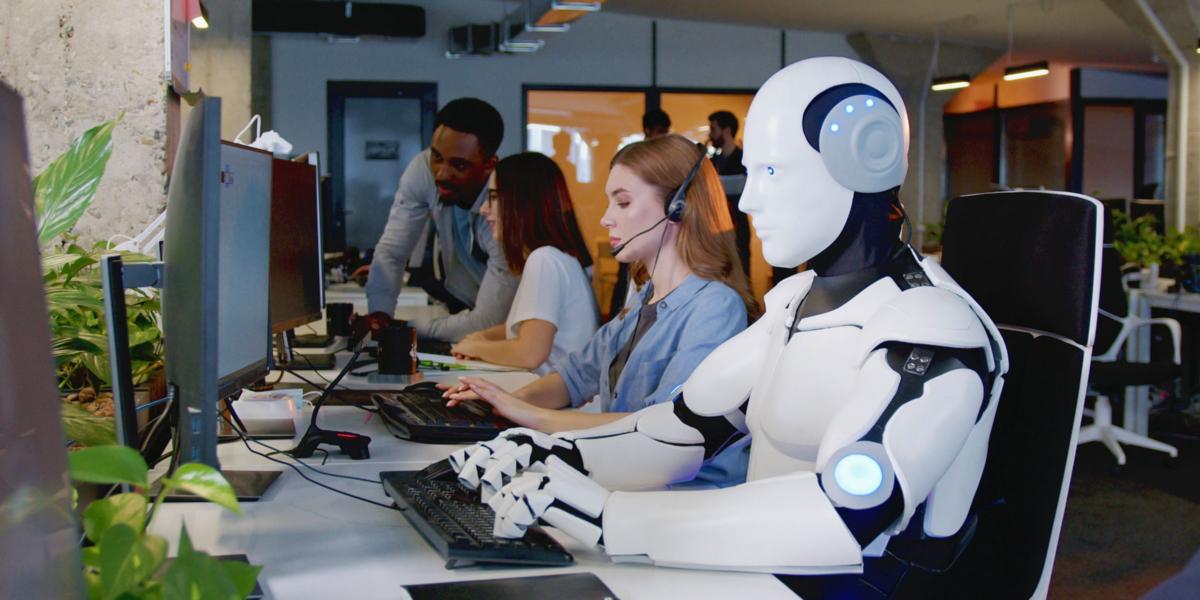 Roboter arbeitet am Computer unter Menschen