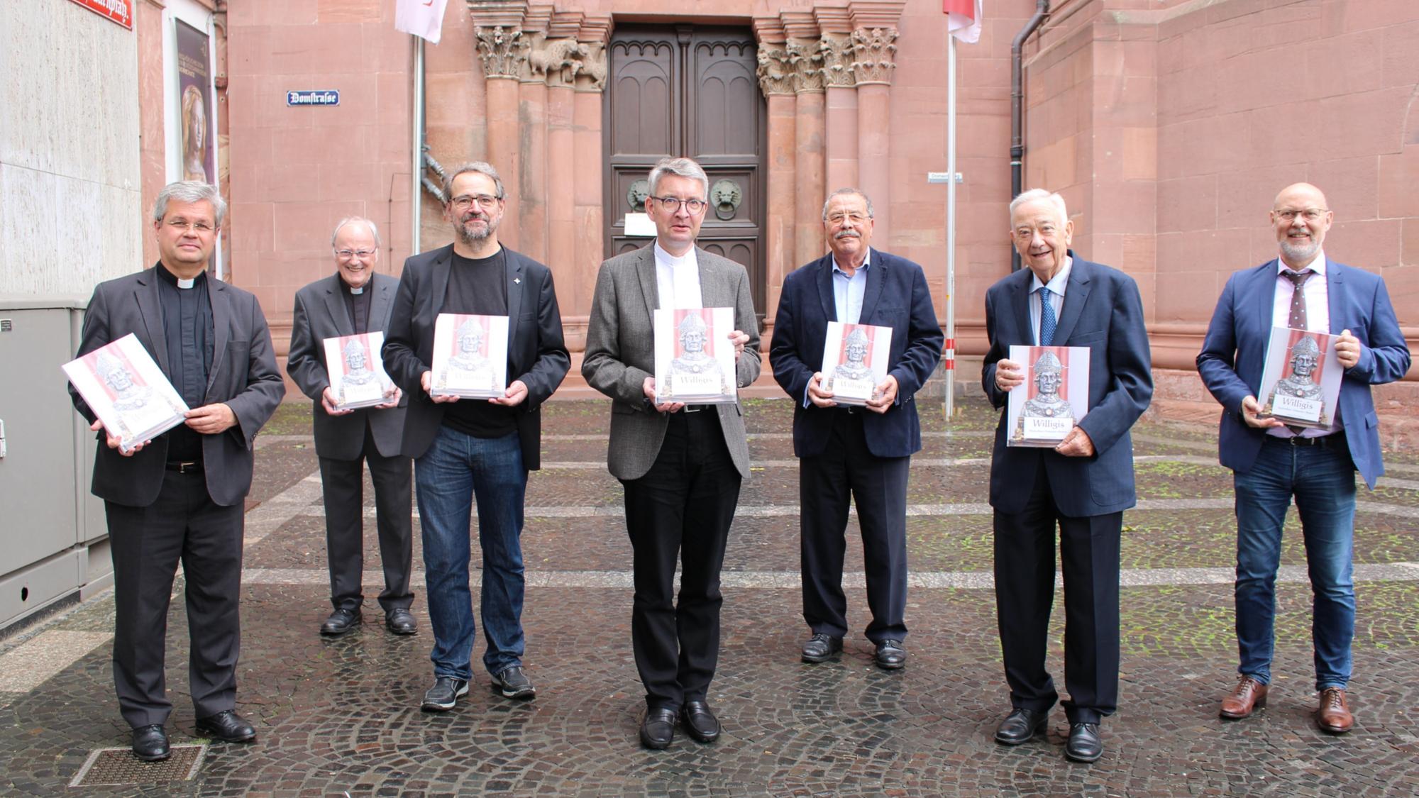 Ein Exemplar des am 25. Juni erschienenen Buches war bereits am Dienstag, 16. Juni, vor dem Mainzer Dom an den Mainzer Bischof Peter Kohlgraf, Weihbischof und Generalvikar Dr. Udo Markus Bentz und den Mainzer Domdekan, Prälat Heinz Heckwolf, überreicht worden.