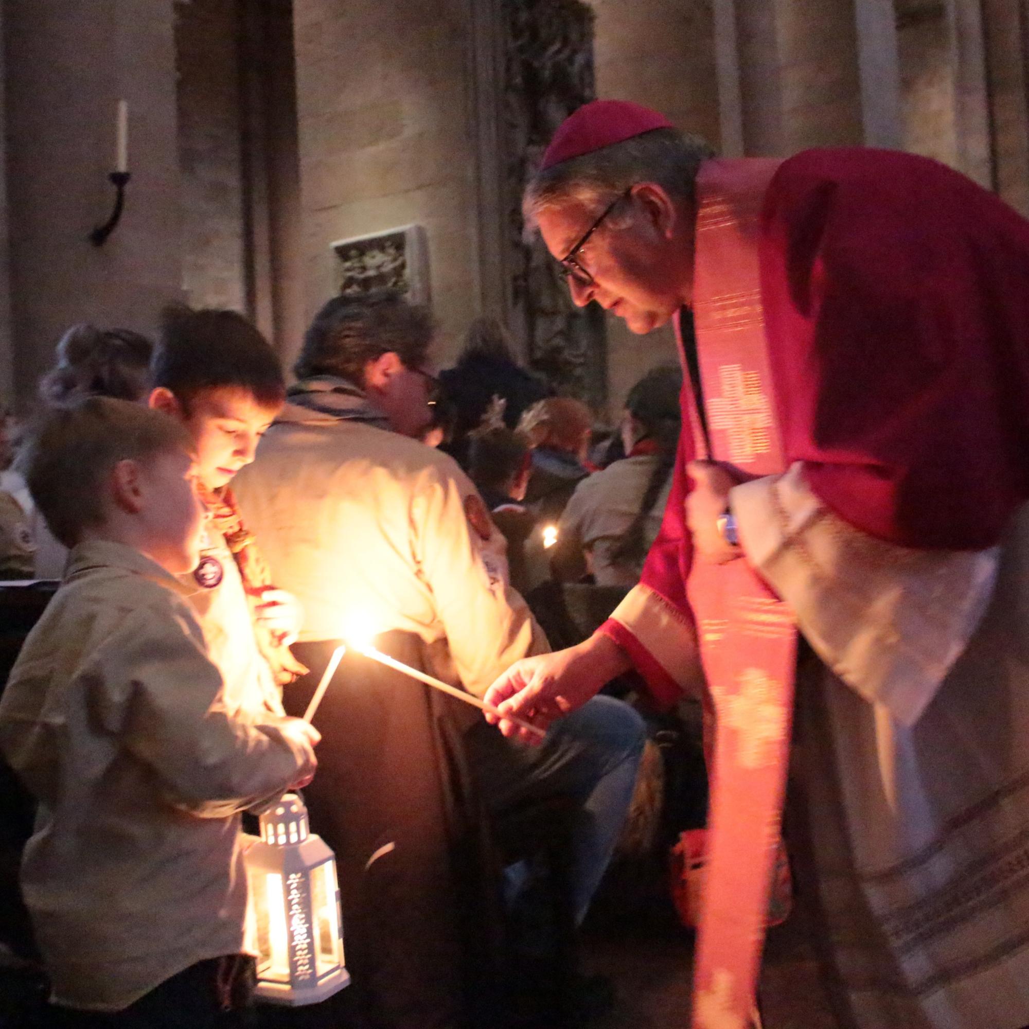 Mainz, 15. Dezember 2024: Bischof Peter Kohlgraf beim Verteilen des Friedenslcihtes aus Bethlehem im Mainzer Dom.