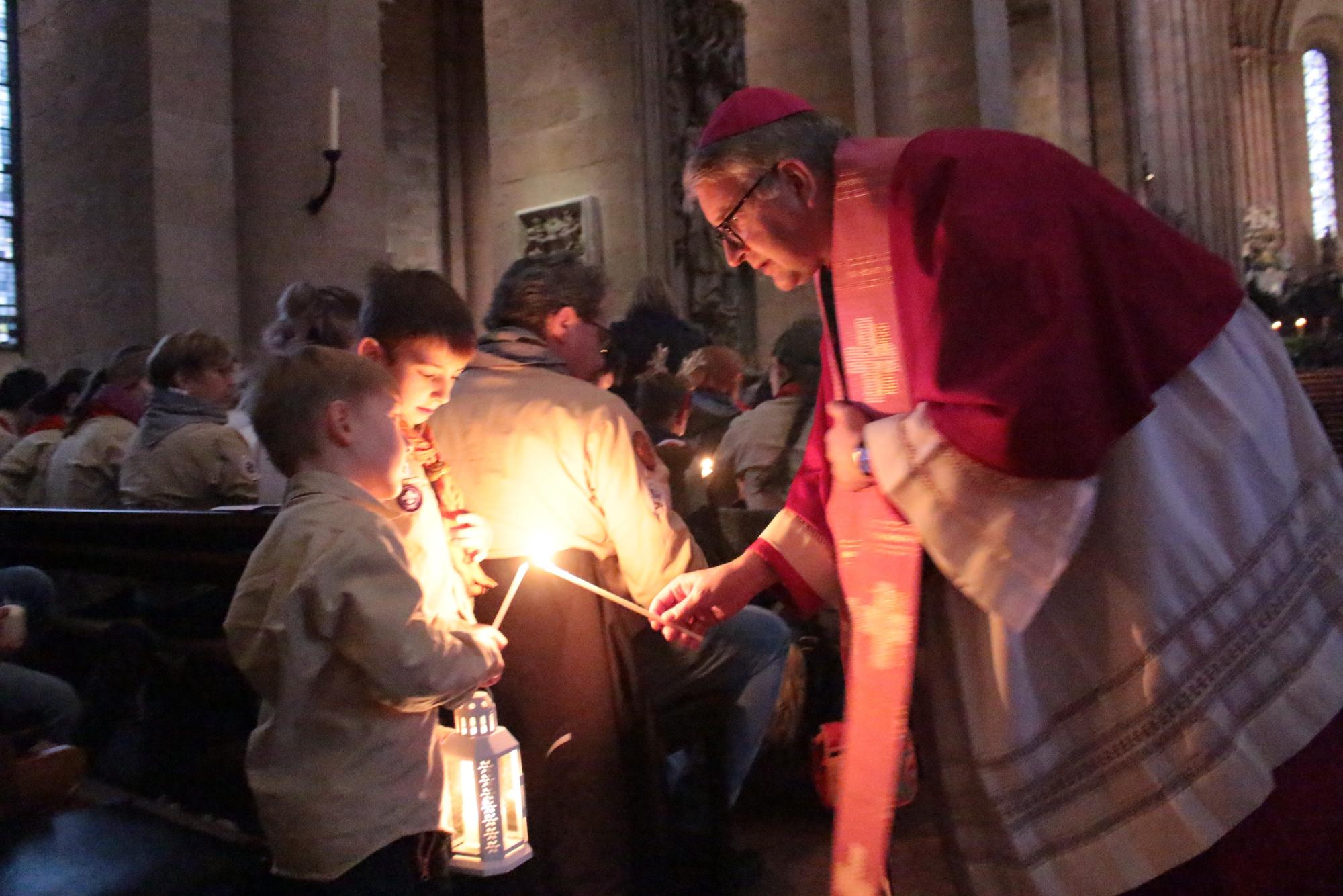 Mainz, 15. Dezember 2024: Bischof Peter Kohlgraf beim Verteilen des Friedenslcihtes aus Bethlehem im Mainzer Dom. (c) Bistum Mainz / Blum