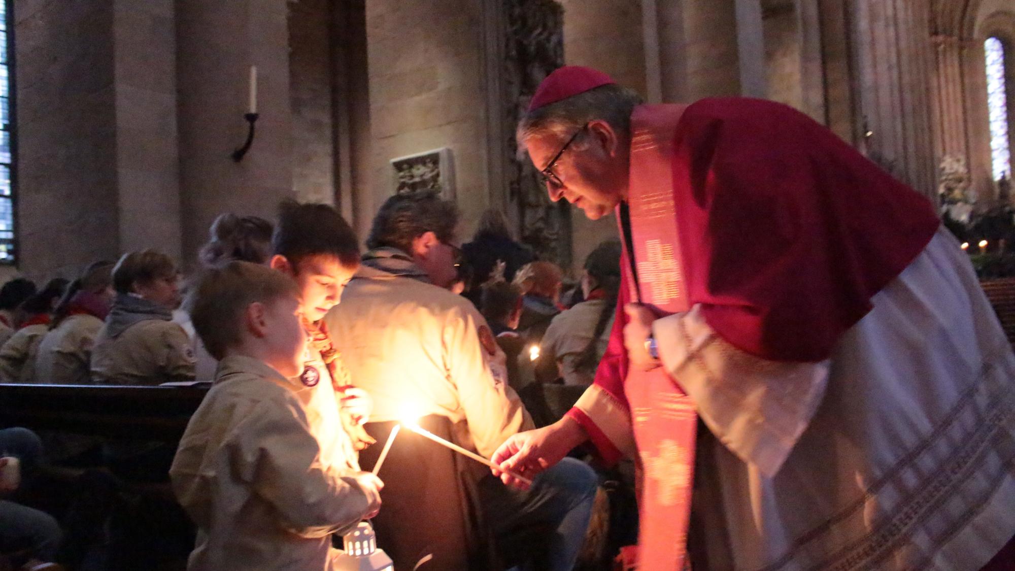 Mainz, 15. Dezember 2024: Bischof Peter Kohlgraf beim Verteilen des Friedenslcihtes aus Bethlehem im Mainzer Dom.