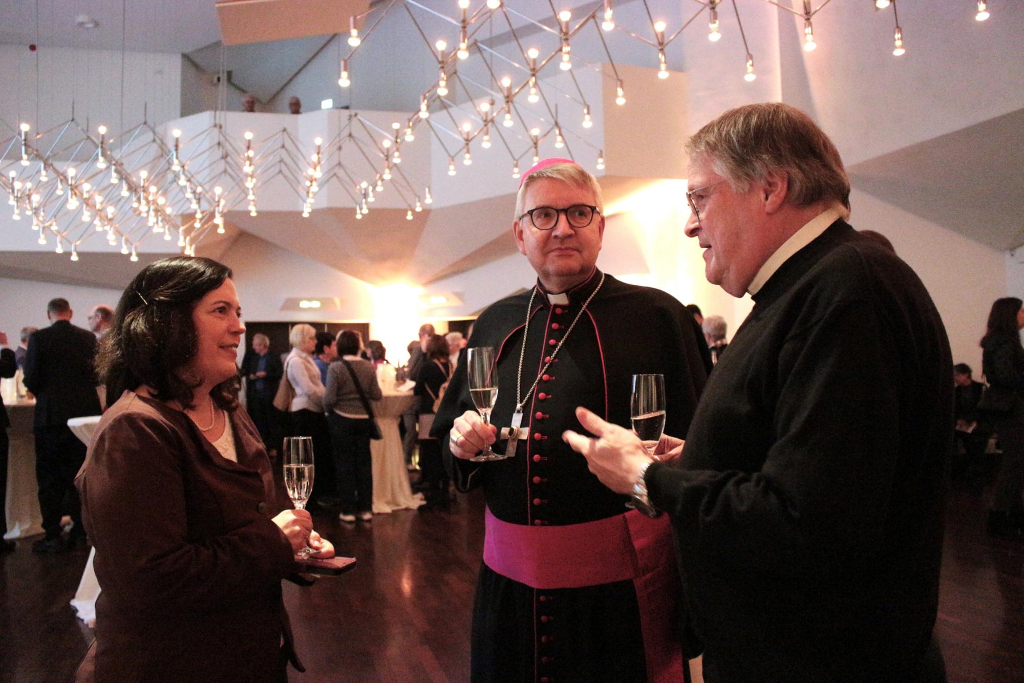Mainz, 16. November 2025: Bischof Peter Kohlgraf im Gespräch bei der Martinusvesper mit der Bevollmächtigten Stephanie Rieth (links) und Prof. Dr. Richard Hartmann (rechts). (c) Bistum Mainz / Blum