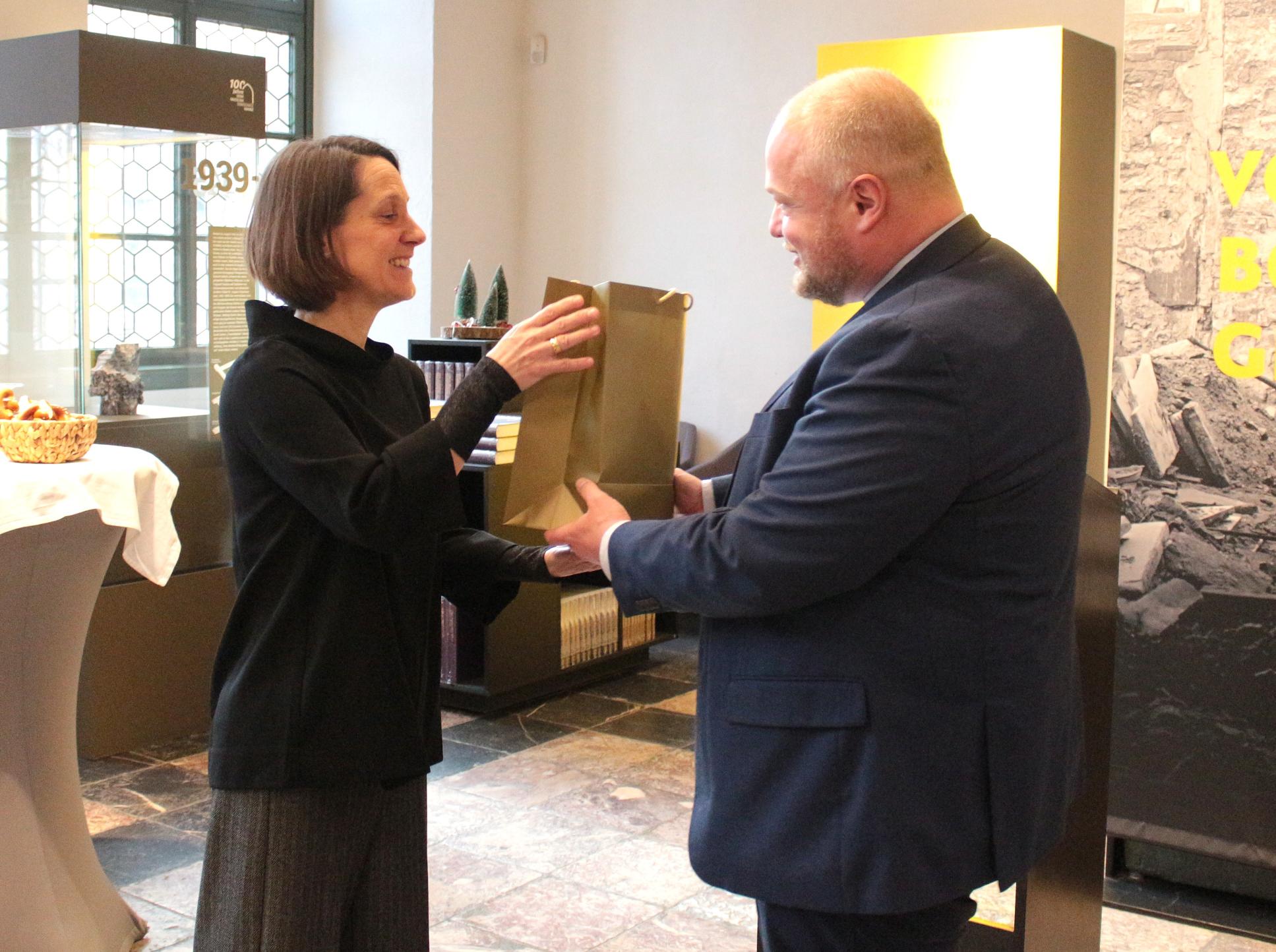 Mainz, 11. Dezember 2025: Generalvikar Sebastian Lang hatte auch ein Begrüßungsgeschenk für die neue Direktorin Anja Lempges (links) dabei. (c) Bistum Mainz / Blum