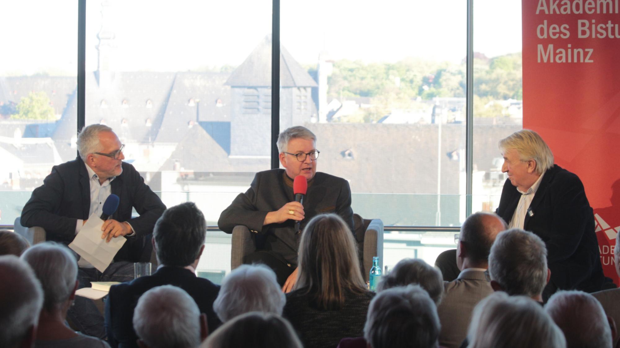 Mainz, 23. April 2026: Gespräch zum Welttag des Buches im Glashaus des Staatstheaters (v.l.n.r.): Alexander Wasner, Bischof Peter Kohlgraf und Hanns-Josef Ortheil.