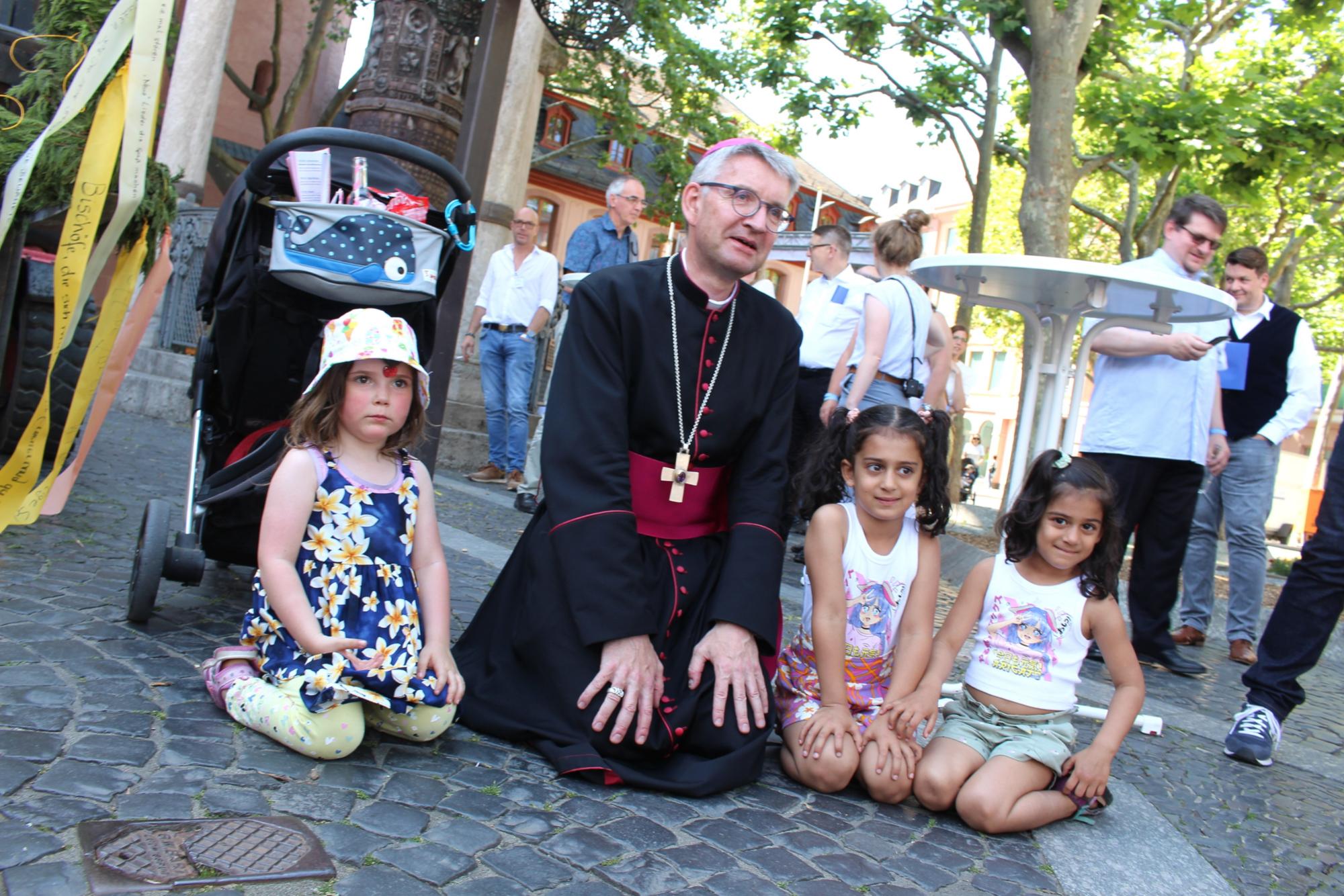 Mainz, 12. Juni 2022: Für Bilder mit kleinen Leuten muss auch Bischof Peter Kohlgraf auf die Knie gehen. (c) Bistum Mainz / Blum