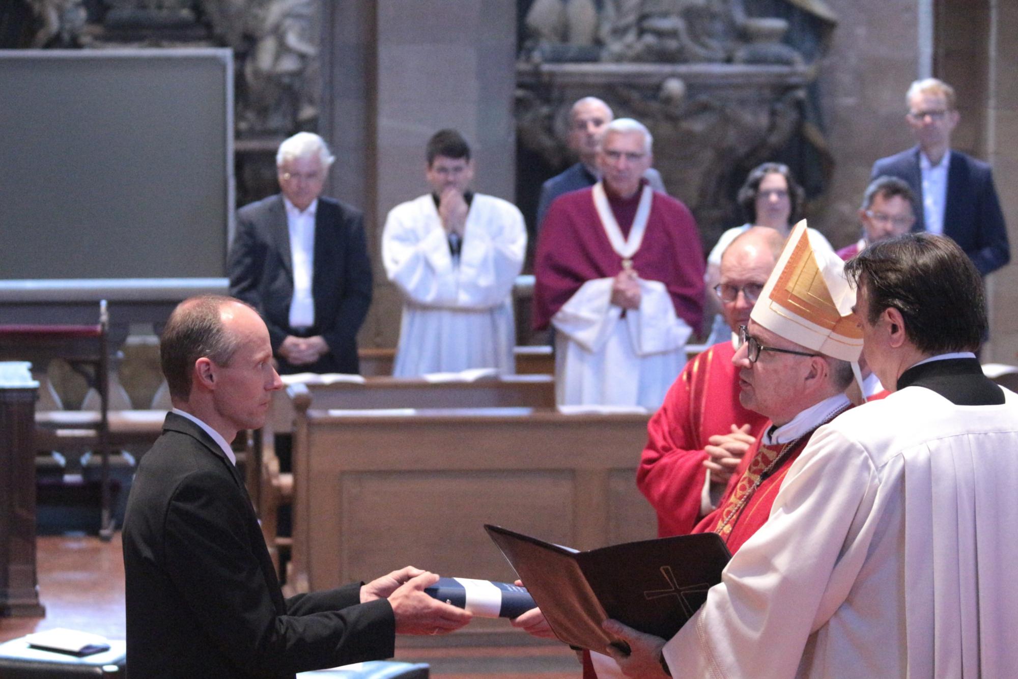 Mainz, 29. Juni 2024: Als Zeichen der Sendung überreicht Bischof Peter Kohlgraf eine Bibel an Gemeindereferent Bernhard Kress. (c) Bistum Mainz / Blum
