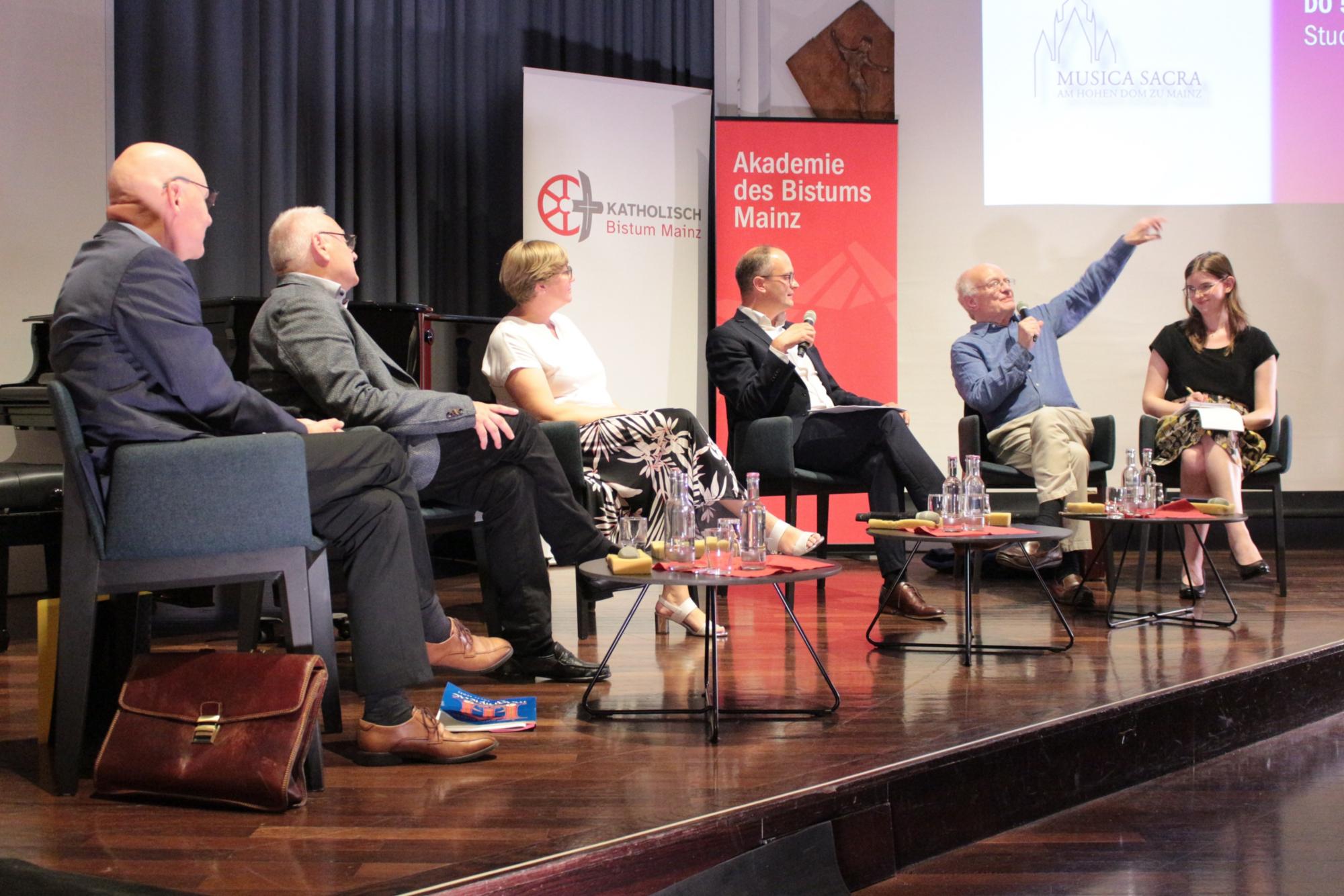 Mainz, 5. September 2024: Gesprächsabend mit und über John Rutter (v.l.n.r.): Walter Hirt, Meinrad Walter, Judith Kunz, Andreas Linsenmann sowie John Rutter mit einer Übersetzerin. (c) Bistum Mainz / Blum