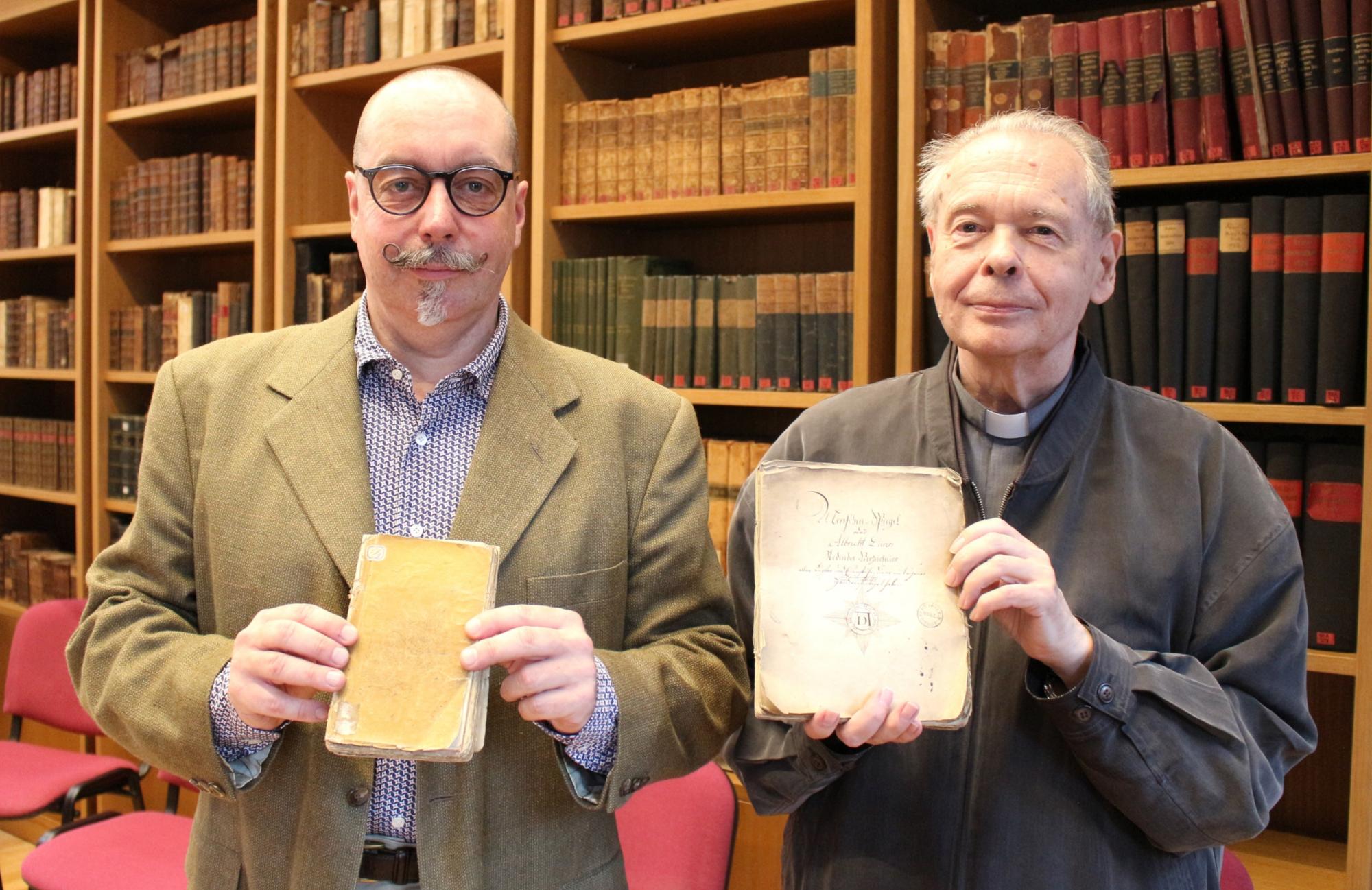 Mainz, 6. Juli 2021: Dr. Gerhard Kölsch (links) und Dr. Helmut Hinkel mit den beiden in der Martinus-Bibliothek wieder entdeckten Manuskripten des Dürer-Werkkataloges. (c) Bistum Mainz / Blum