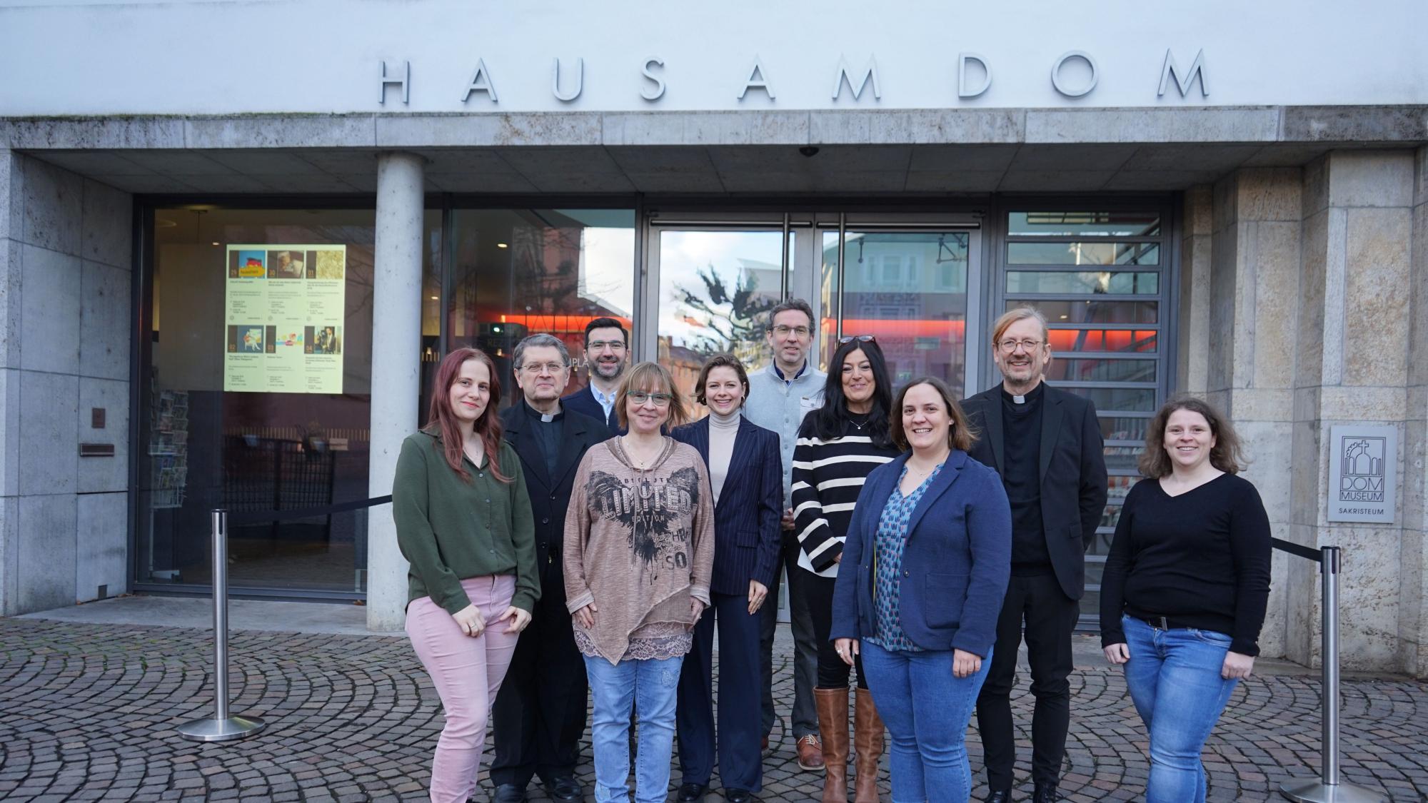 Frankfurt, 29. Januar 2025: Die Mitarbeitenden des Gemeinsamen Offizialates vor dem Haus am Dom in Frankfurt (v.l.n.r.). Erste Reihe: Eva Kleiß, Notarin, Jutta Stähler, Notarin, Josa Merkel, Diözesanrichterin, Sandra Finger, Notarin. Zweite Reihe: Joachim Respondek, Vizeoffizial, Julia Adams, Ehebandverteidigerin, Silke Rittau, Notarin, Olaf Lindenberg, Offizial. Dritte Reihe: Dan-Christian Visa, Diözesanrichter, Alexander Becker, Diözesanrichter.  Auf dem Foto fehlen: P. Klemens Raczek O.Carm, Ehebandverteidiger; P. Dr. Albert Sieger OSB, Ehebandverteidiger.