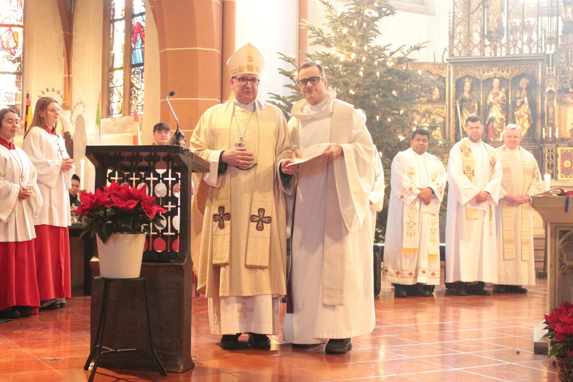 Gießen, 11. Januar 2026: Bischof Peter Kohlgraf übergab das Gründungsdekret für die neue Pfarrei an Pfarrer Benjamin Weiß (rechts). (c) Bistum Mainz / Blum