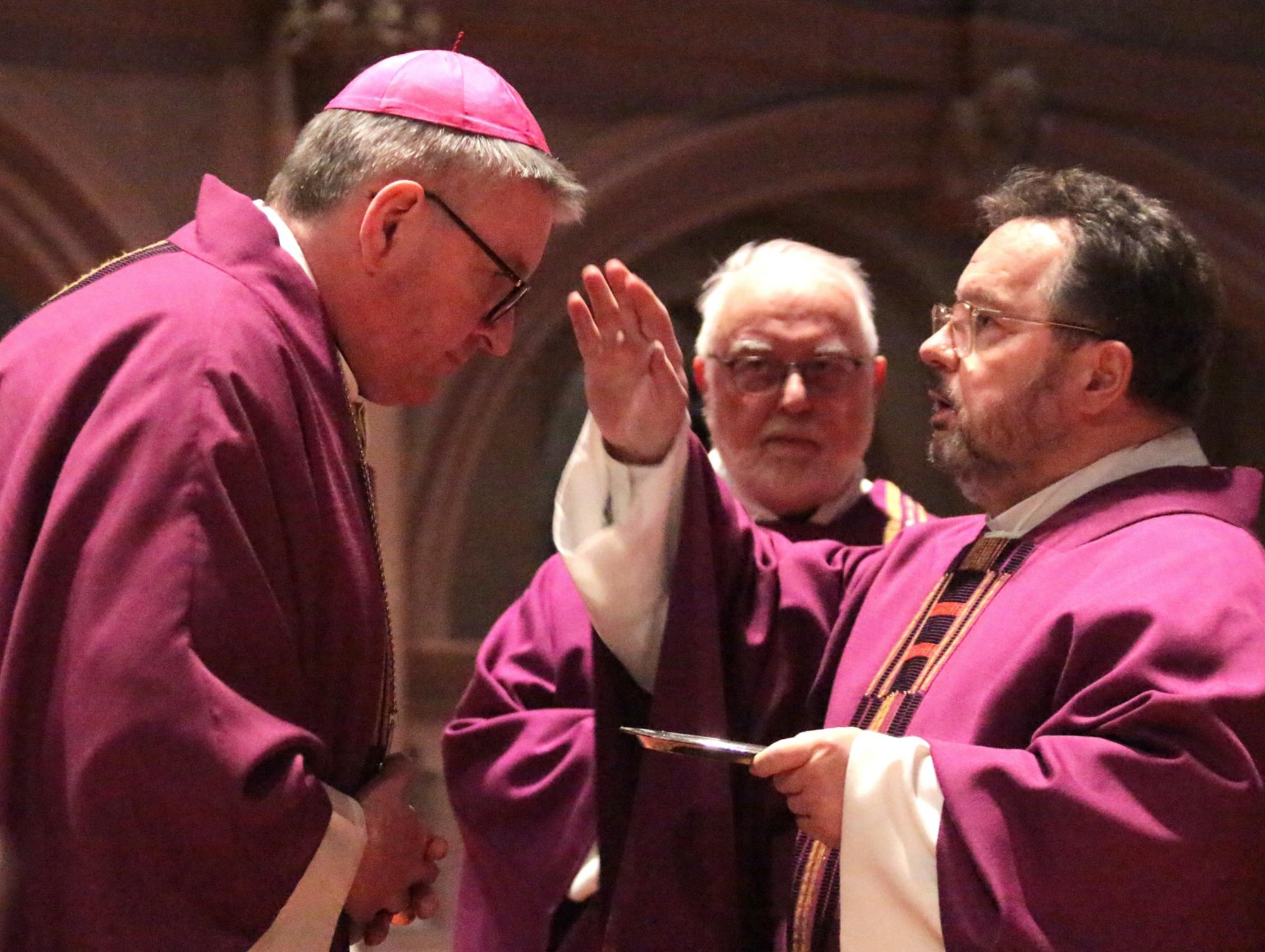 Mainz, 18. Februar 2026: Der Mainzer Domdekan Henning Priesel (rechts) zeichnet Bischof Peter Kohlgraf an Aschermittwoch im Mainzer Dom mit Asche ein Kreuz auf die Stirn. (c) Bistum Mainz / Blum