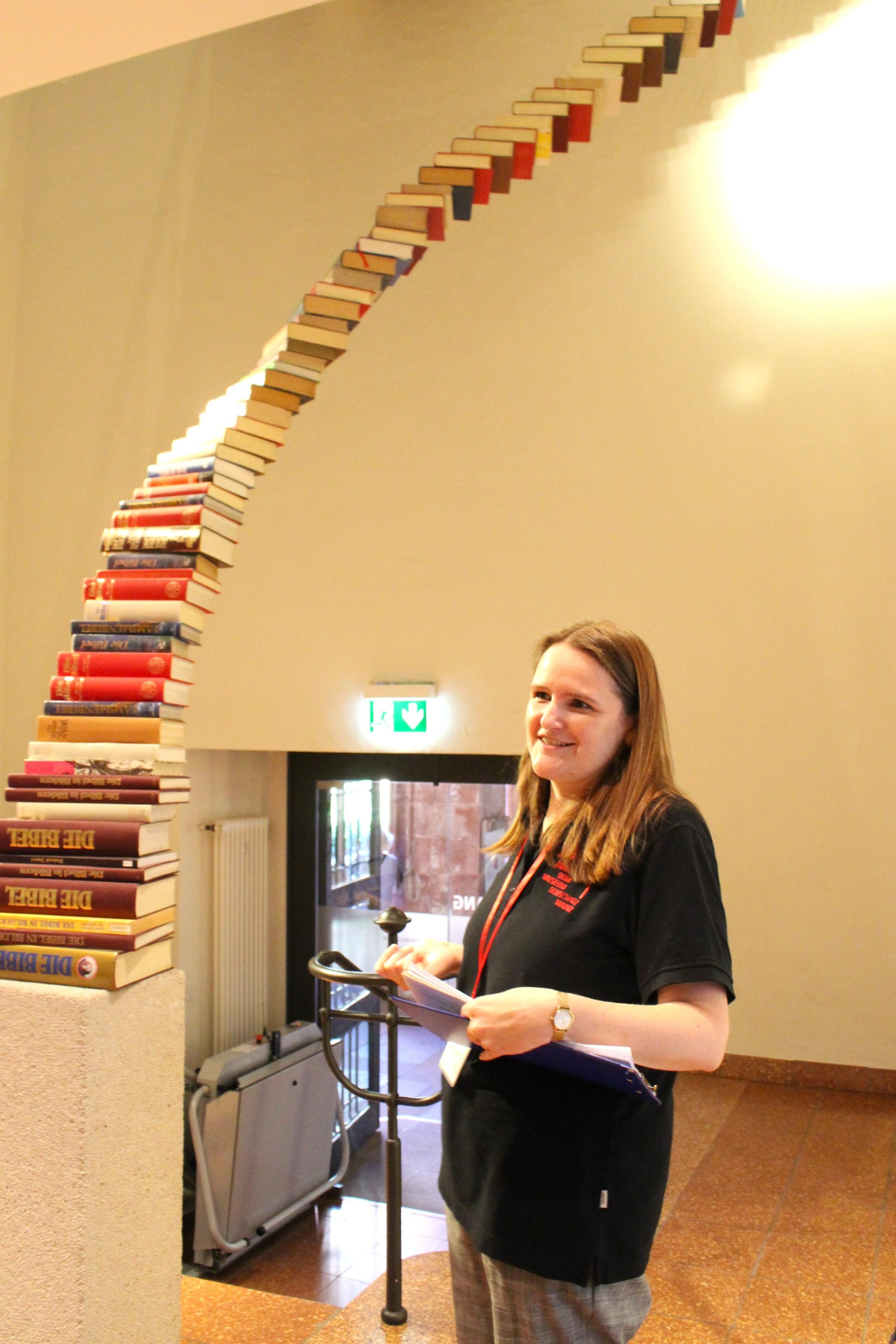 Mainz, 6. September 2026: Kunsthistorikerin Sabrina Faulstich erläutert die Büchertreppe 'Stairway to heaven' von Jochen Höller, eines der modernen Werke im Mainzer Dom- und Diözesanmuseum.