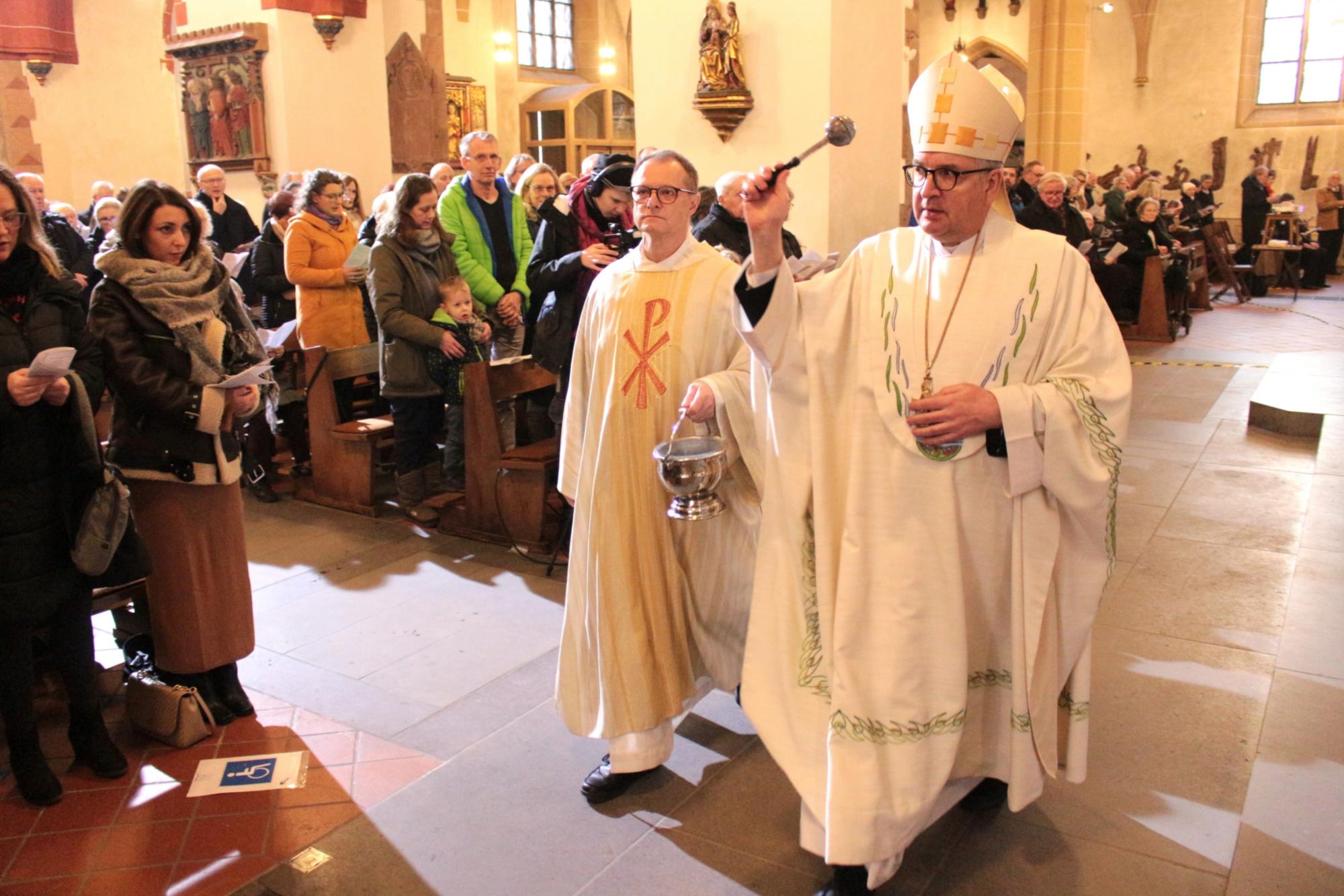 Bingen, 19. Januar 2025: Beim Taufgedächtnis ging Bischof Peter Kohlgraf gemeinsam mit Diakon Martin Trageser (links) mit Weihwasser durch die Basilika St. Martin. (c) Bistum Mainz / Blum