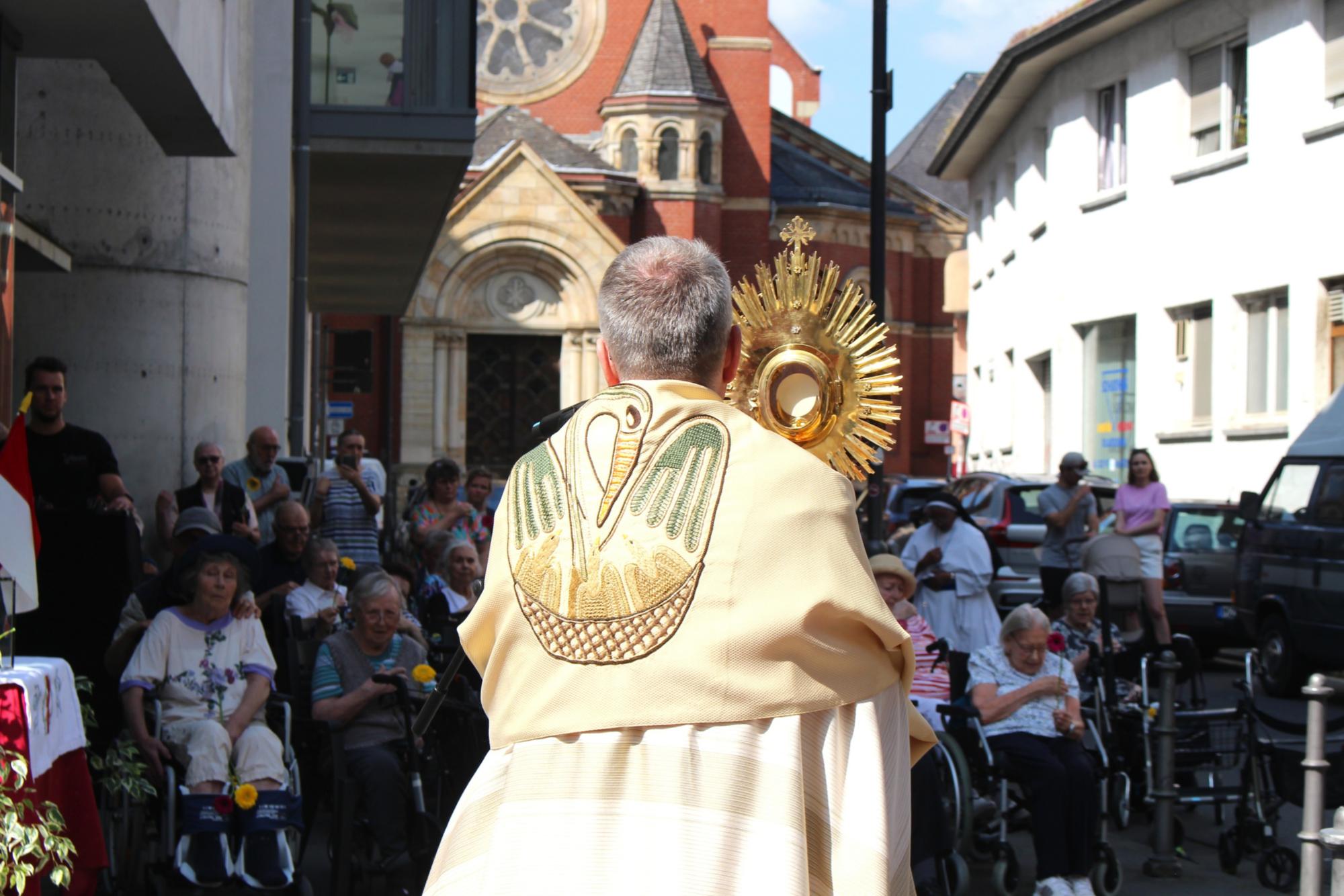 Mainz, 19. Juni 2025: Vor dem Bruder Konrad-Stift fand eine kurze Statio statt. Bischof Kohlgraf spendete den Bewohnern den Segen mit der Monstranz. (c) Bistum Mainz / Blum