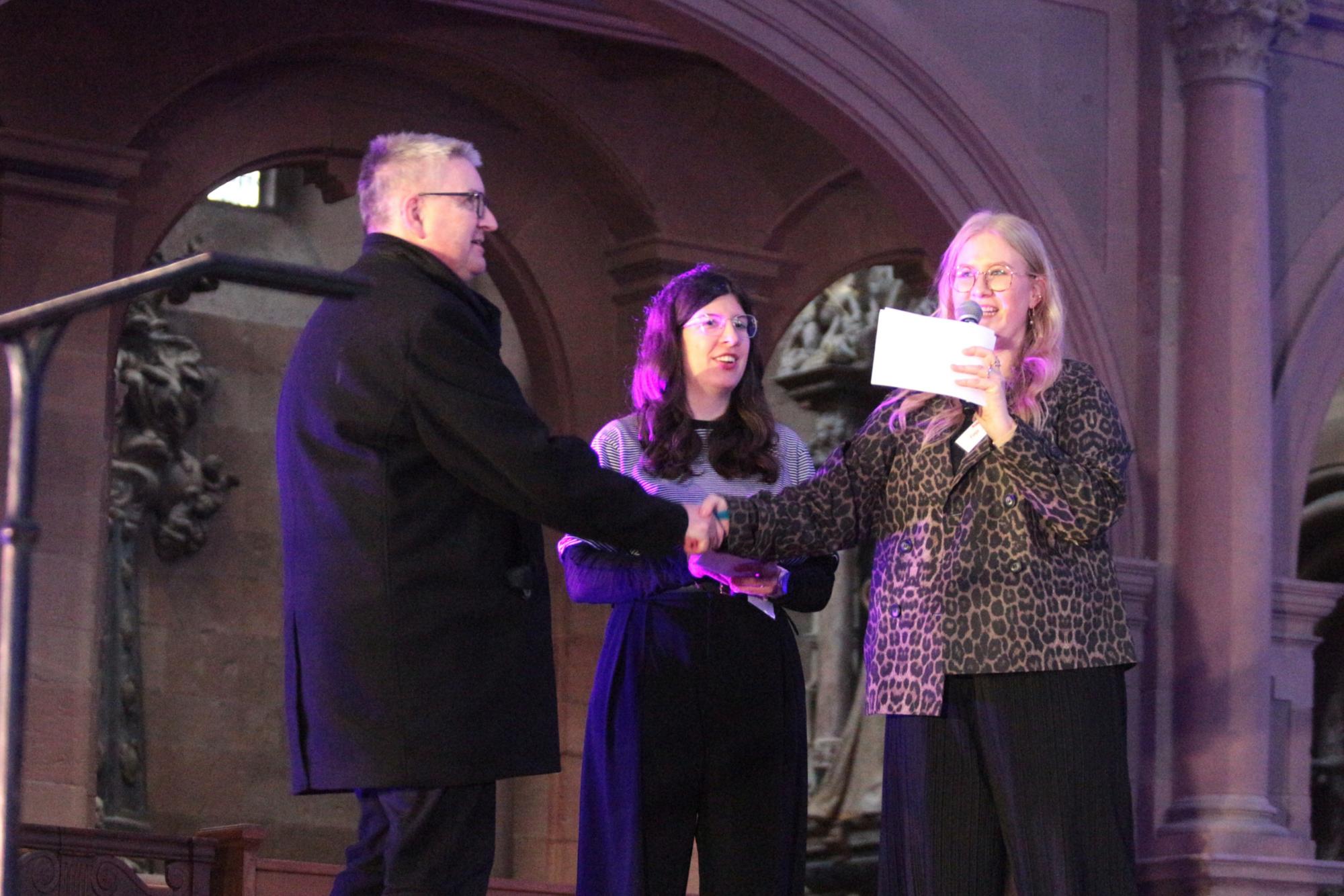 Mainz, 28. März 2026: Die Moderatorinnen Sophie Eberle (mitte) und Finja Fiedler (rechts) begrüßten Bischof Peter Kohlgraf zur kurzen Fragerunde beim Auftakt des Firmbewerbertages. (c) Bistum Mainz / Blum