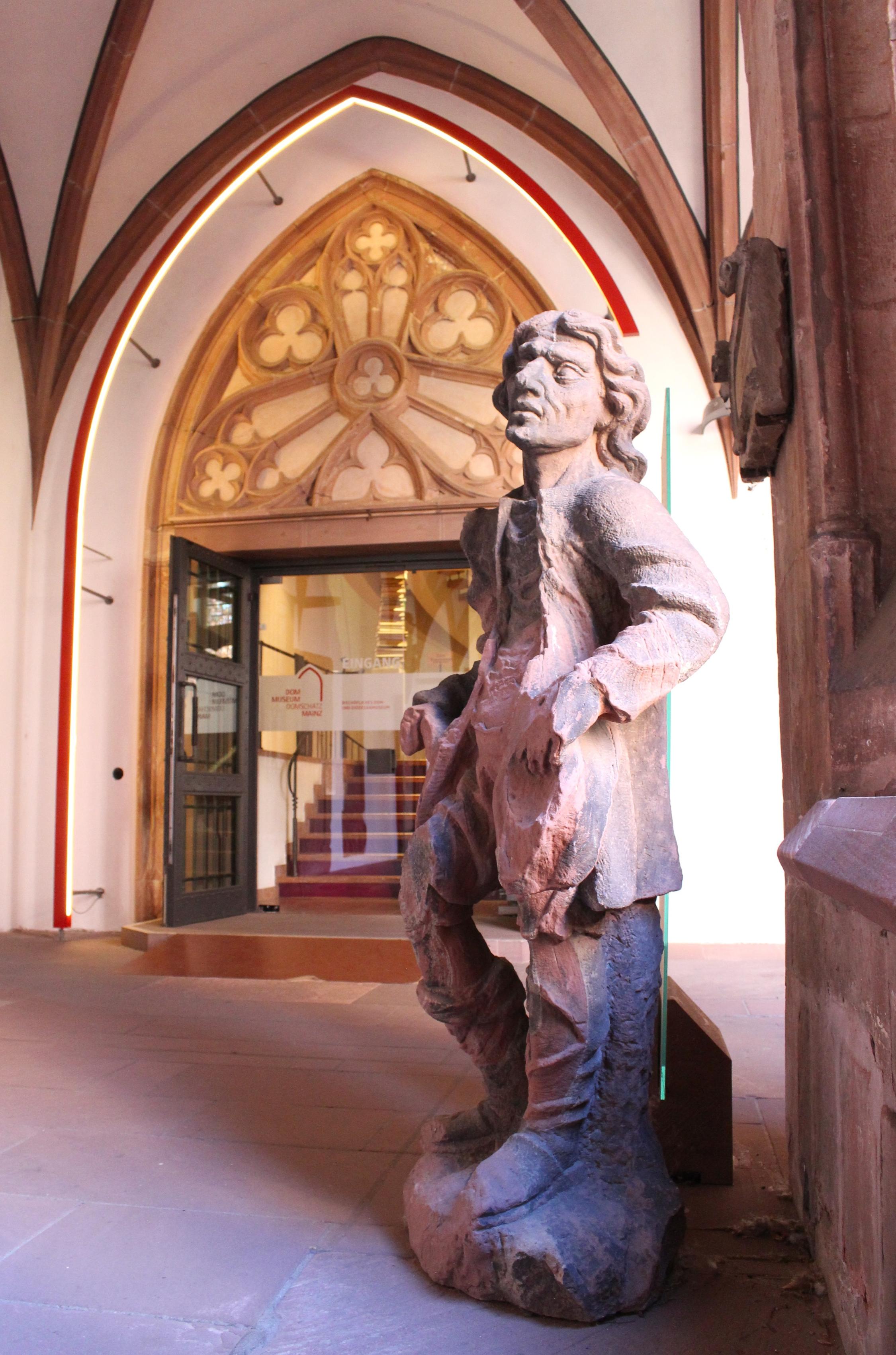 Mainz, 6. September 2026: Der Betteler aus der Martinusgruppe vom Dach des Mainzer Domes steht aktuell vor dem Eingang des Dom- und Diözesanmuseums im Kreuzgang des Mainzer Domes.