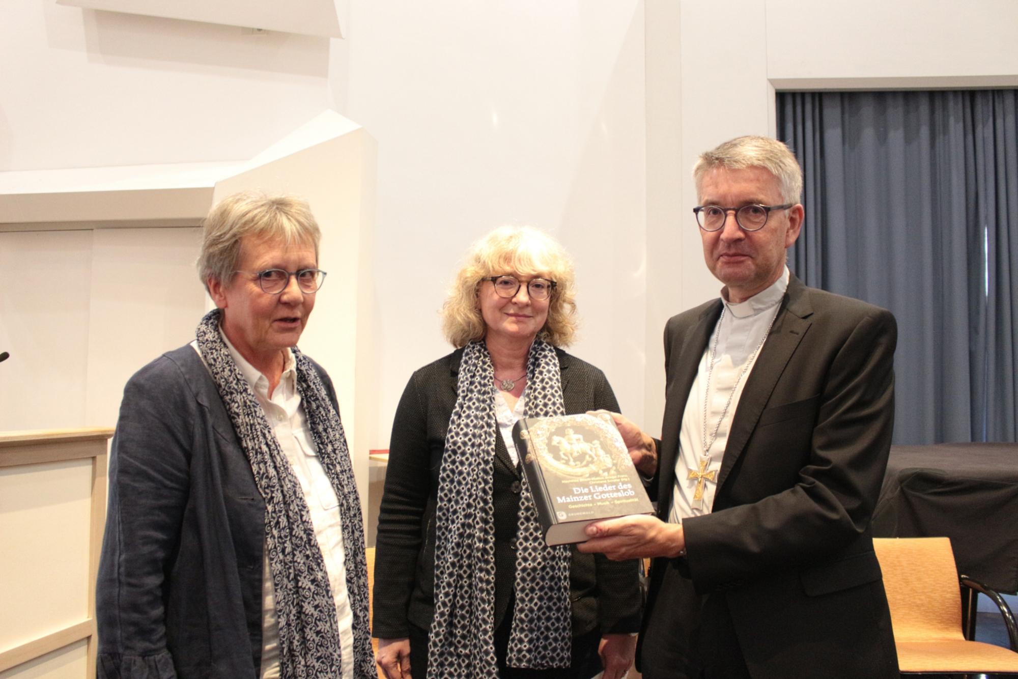 Mainz, 17. September 2022: Übergabe der Neuerscheinung an Bischof Kohlgraf durch die Herausgeberinnen Mechthild Bitsch-Molitor (links) und Christiane Schäfer (mitte).