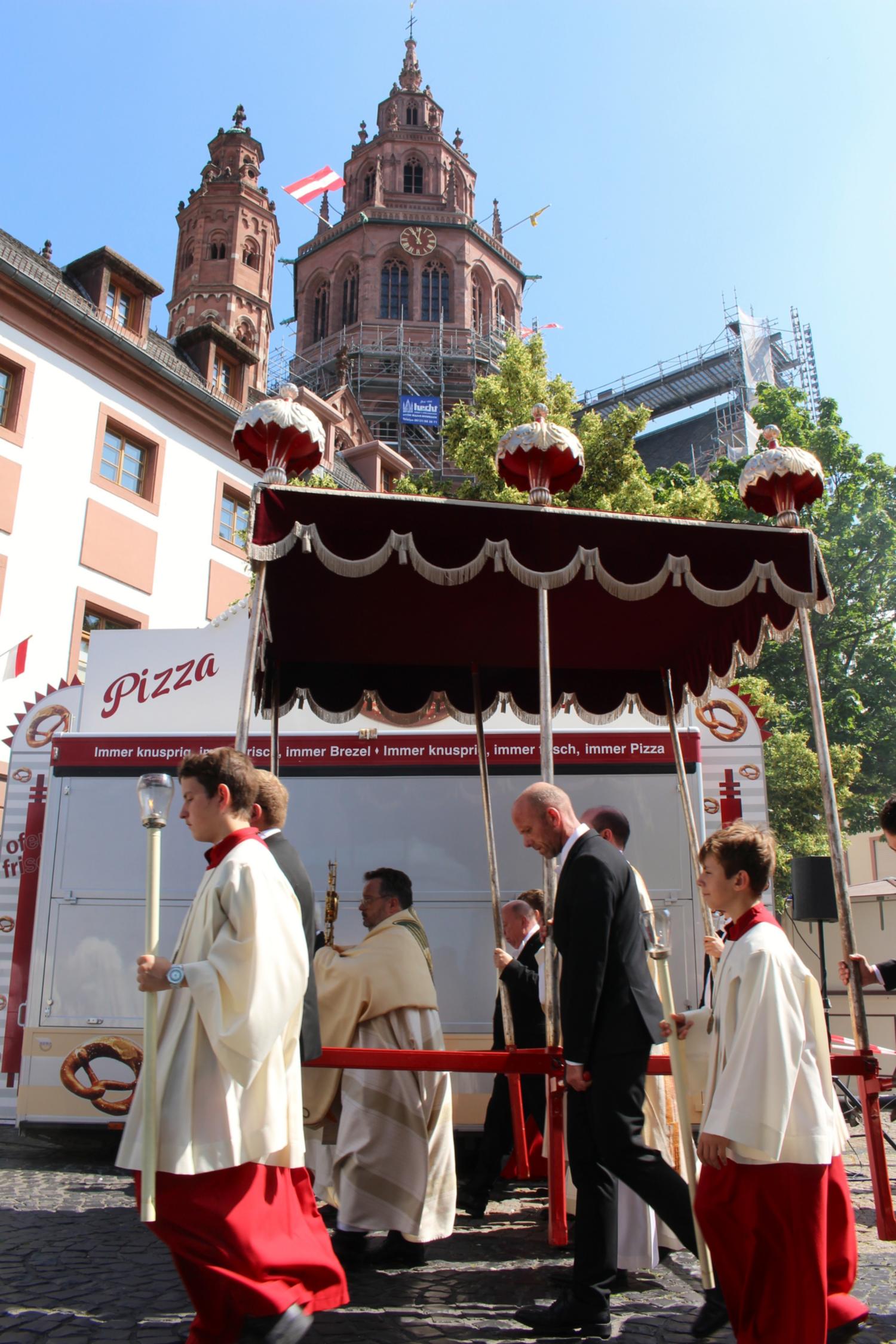 Mainz, 19. Juni 2025: Der Mainzer Domdekan Henning Priesel trug die Monstranz auf dem zweiten Teil des Prozessionsweges, hier vor den Ständen des Johannisfestes auf dem Leichhof. (c) Bistum Mainz / Blum