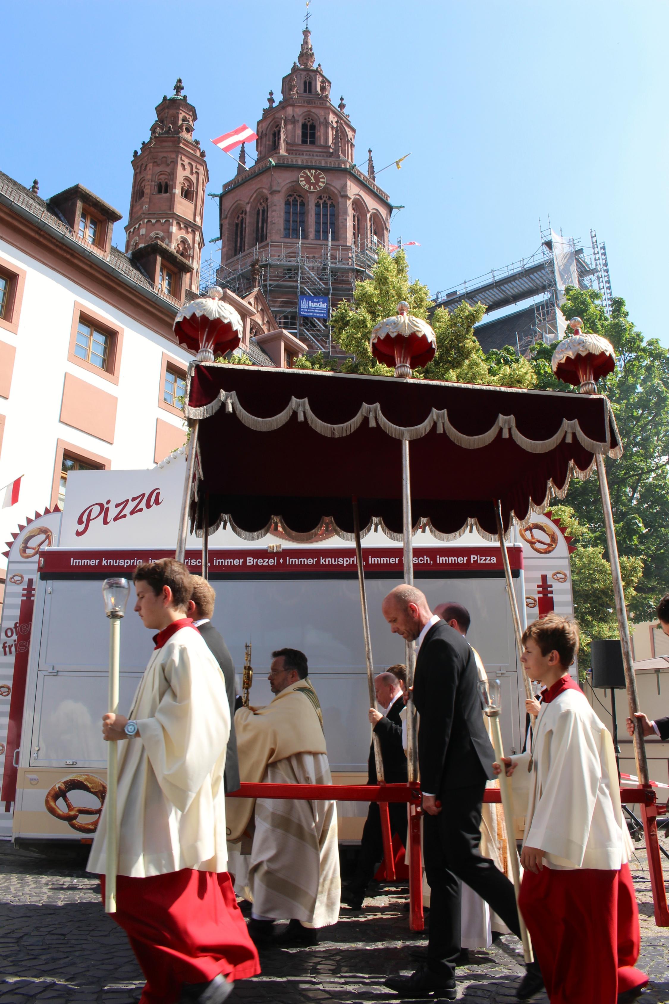 Mainz, 19. Juni 2025: Der Mainzer Domdekan Henning Priesel trug die Monstranz auf dem zweiten Teil des Prozessionsweges, hier vor den Ständen des Johannisfestes auf dem Leichhof.