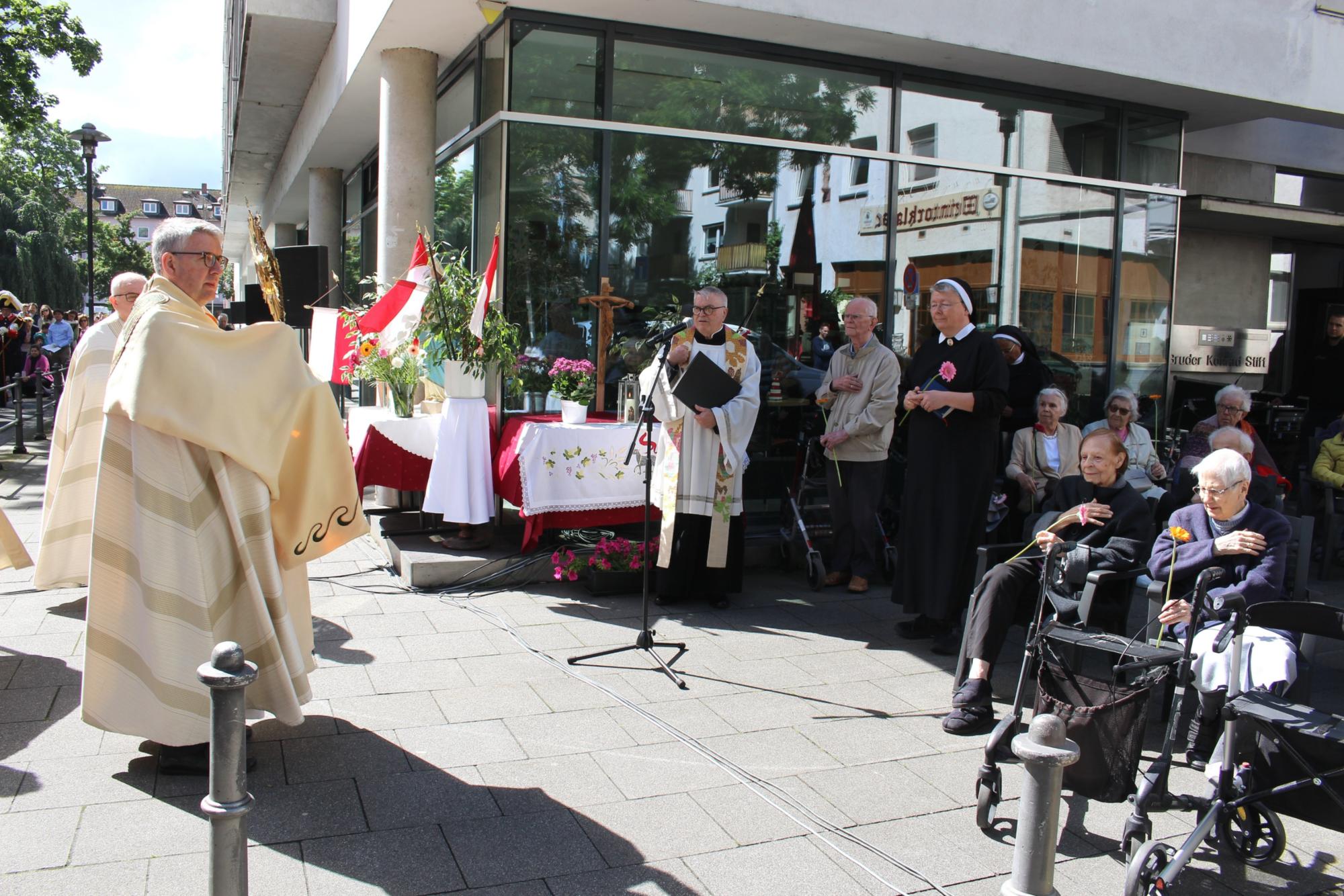 Mainz, 30. Mai 2024: Bischof Peter Kohlgraf spendete bei einer Statio vor dem Bruder Konrad-Stift mit der Monstranz den Segen. (c) Bistum Mainz / Blum