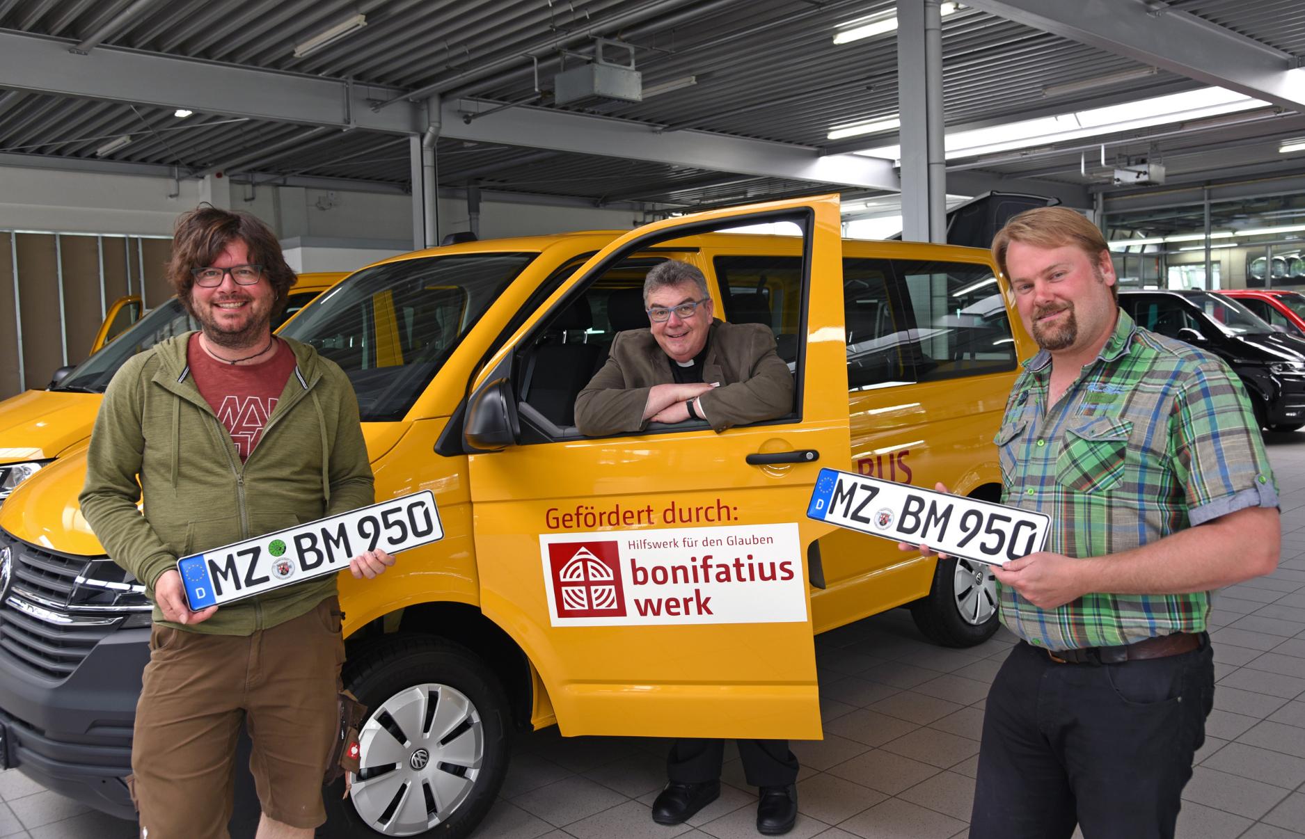 Für das Bischöfliche Jugendamt in Mainz haben Sebastian Besier (r.) und Bernhard Unselt den neuen BONI-Bus abgeholt. Übergeben wurde ihnen das Fahrzeug von Monsignore Georg Austen. (c) Foto: Patrick Kleibold