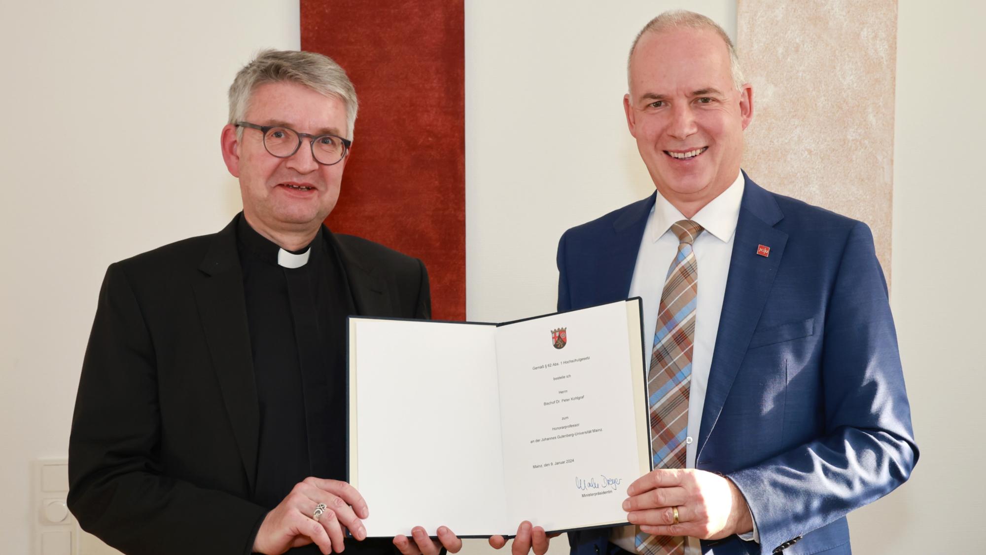 Bischof Peter Kohlgraf erhält die Ernennungsurkunde zum Honorarprofessor der Johannes Gutenberg-Universität Mainz vom Präsidenten der Universität, Georg Krausch