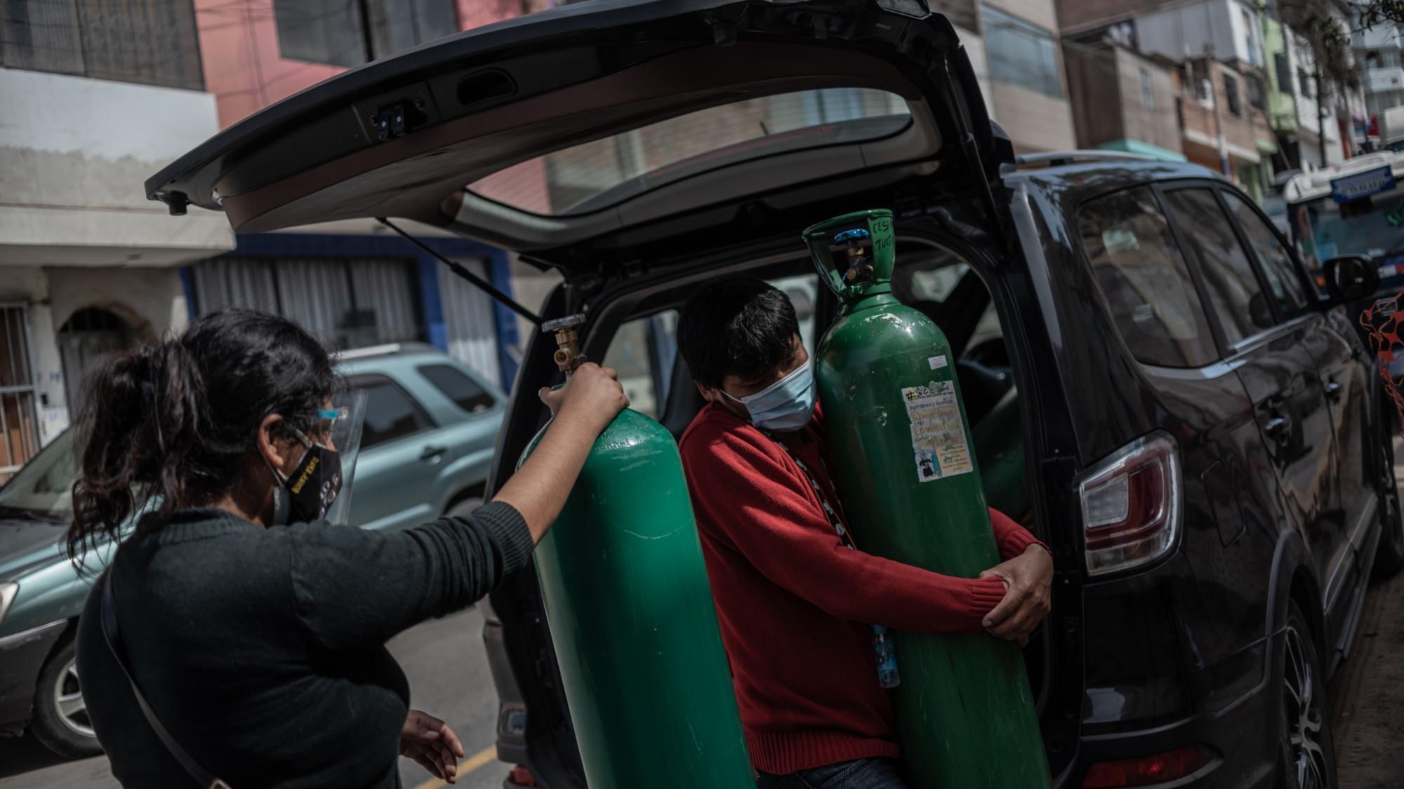 Überlebensnotwendig: Nora Cerron und ein Nachbar lassen ihre Sauerstoffflaschen in der Pfarrei Cristo Misionero del Padre auffüllen.