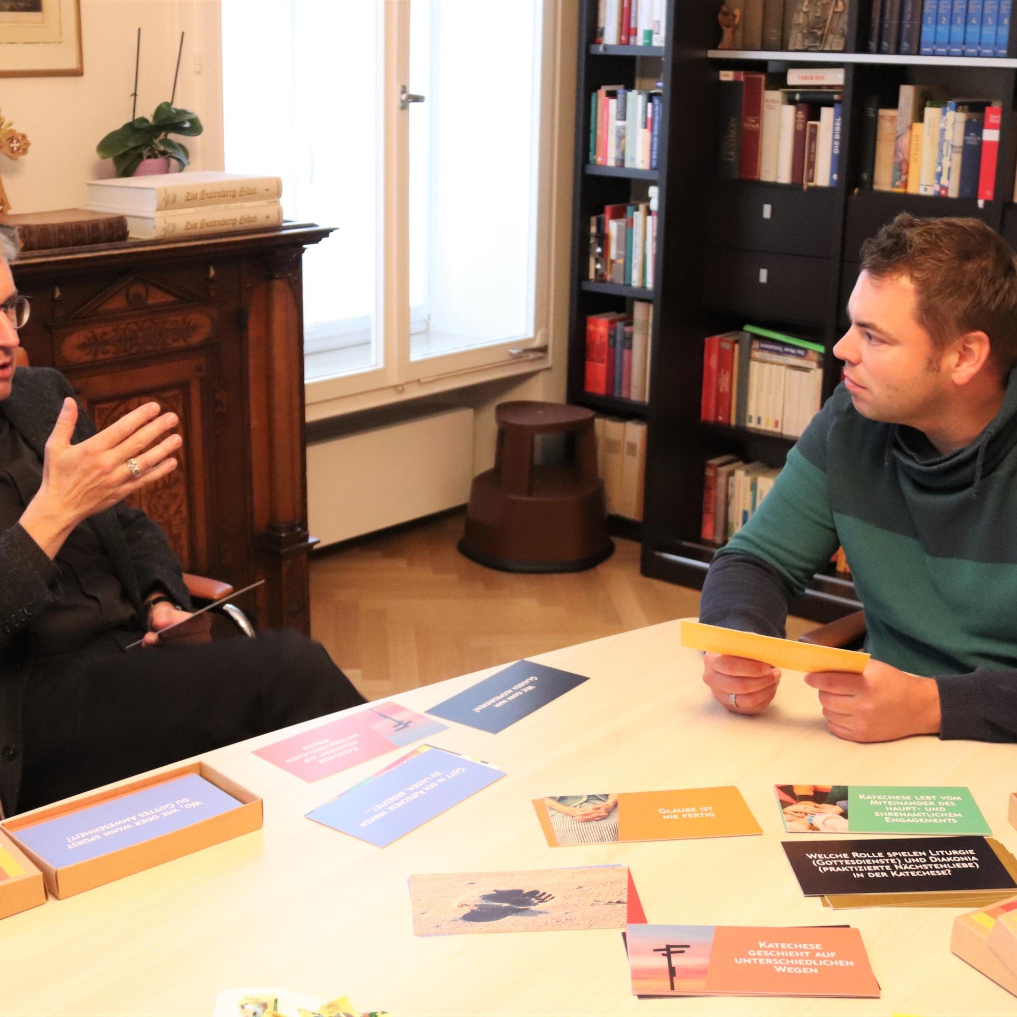 Bischof Peter Kohlgraf und Aaron Torner, Referent für Katechese im Bistum Mainz, tauschen sich über ein neues Kartenset mit dem Titel „Katechese – Eine Frage der Haltung?!“ aus
