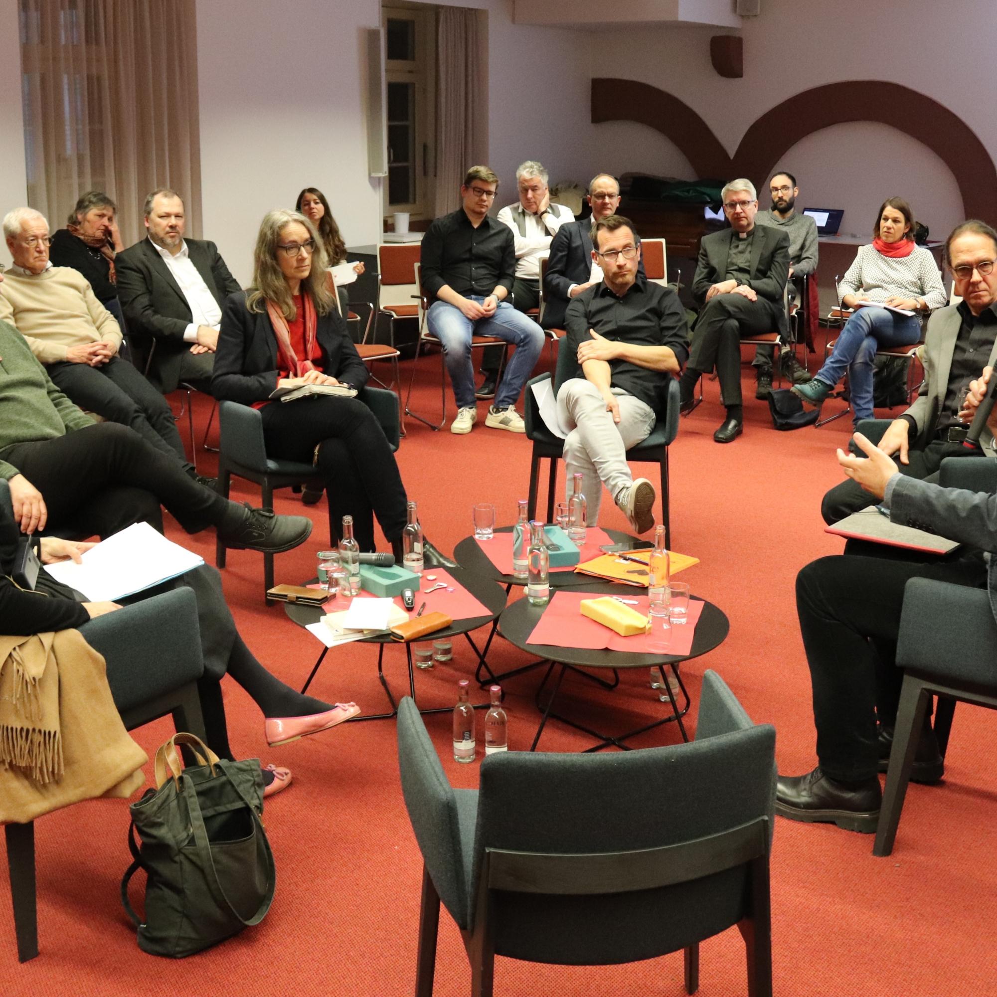 Diskussionsrunde zum Thema Klimakommunikation - vorne im Bild der leere Stuhl für spontan Mitdiskutierende