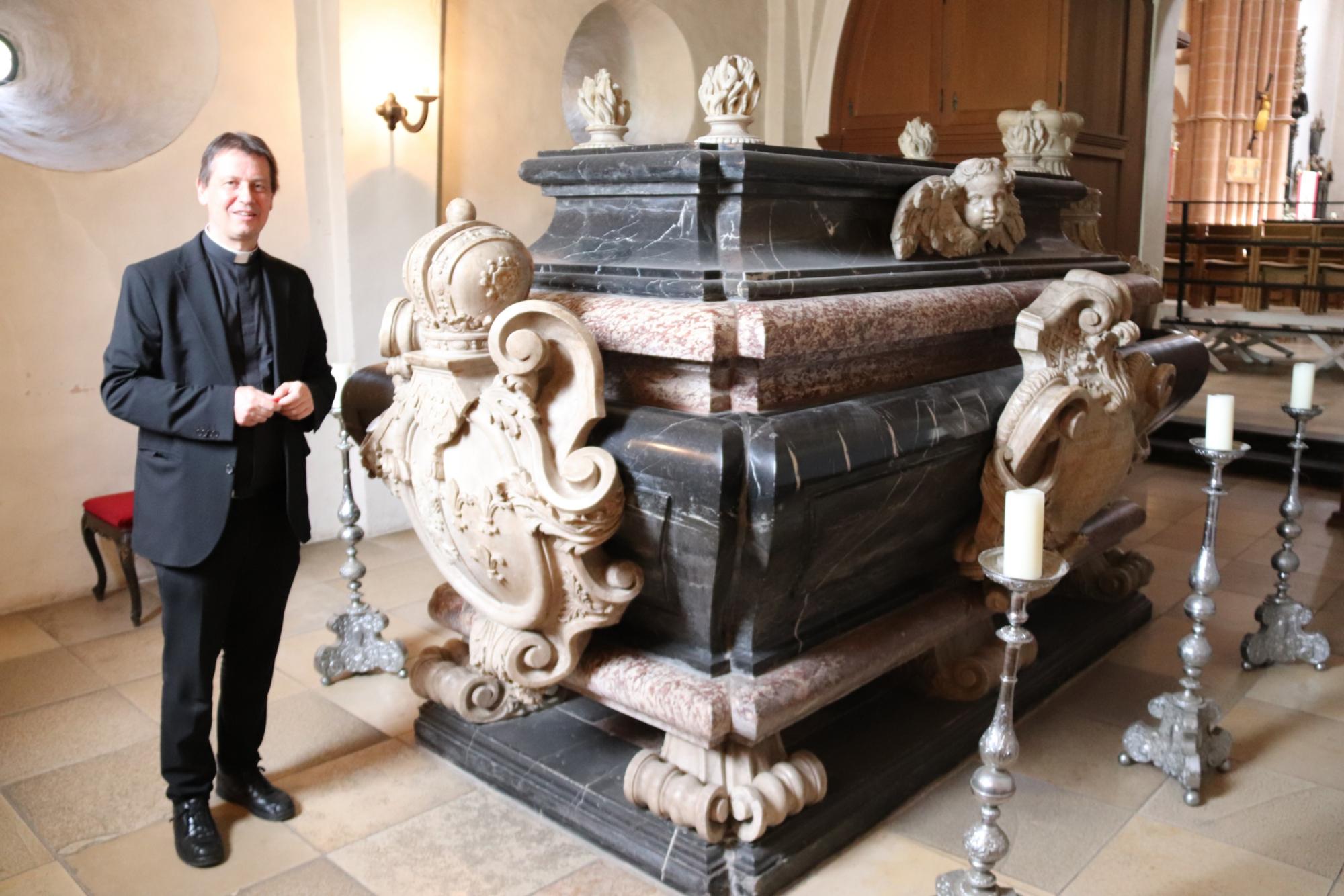 Pfarrer Stefan Selzer neben dem Sarkophag des Gründerpaars Einhard und Emma (c) Bistum Mainz/Hoffmann